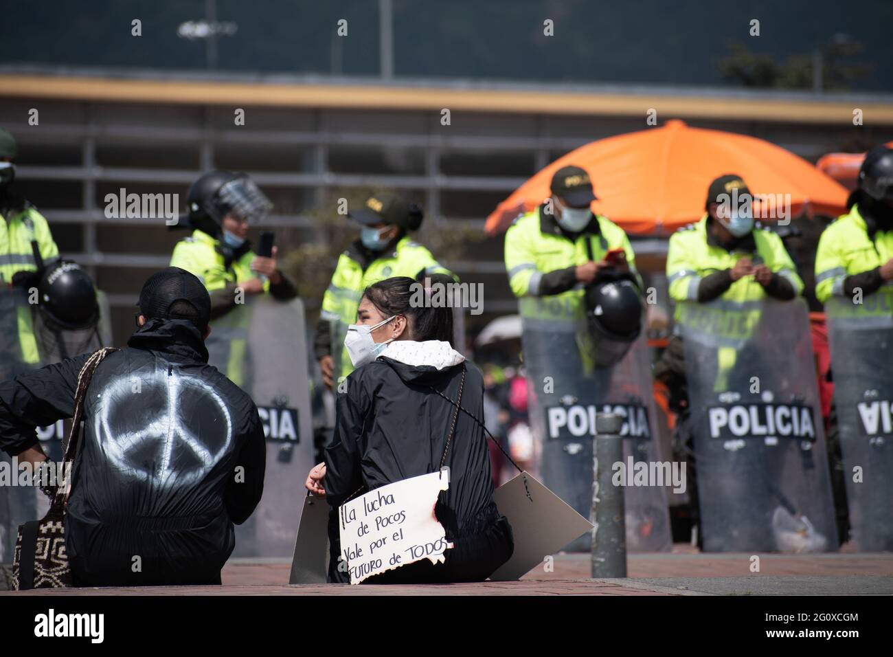 Bogota, Cundinamarca, Colombia. 2nd June, 2021. With the police behind her, a protester holds up a sign that reads ''Everyone's Fight for Everyone's Values.'' on a new day of anti-government protest in BogotÃ¡, Colombia against the government of President IvÃ¡n Duque and police brutality on June 2, 2021 Credit: Daniel Romero/LongVisual/ZUMA Wire/Alamy Live News Stock Photo