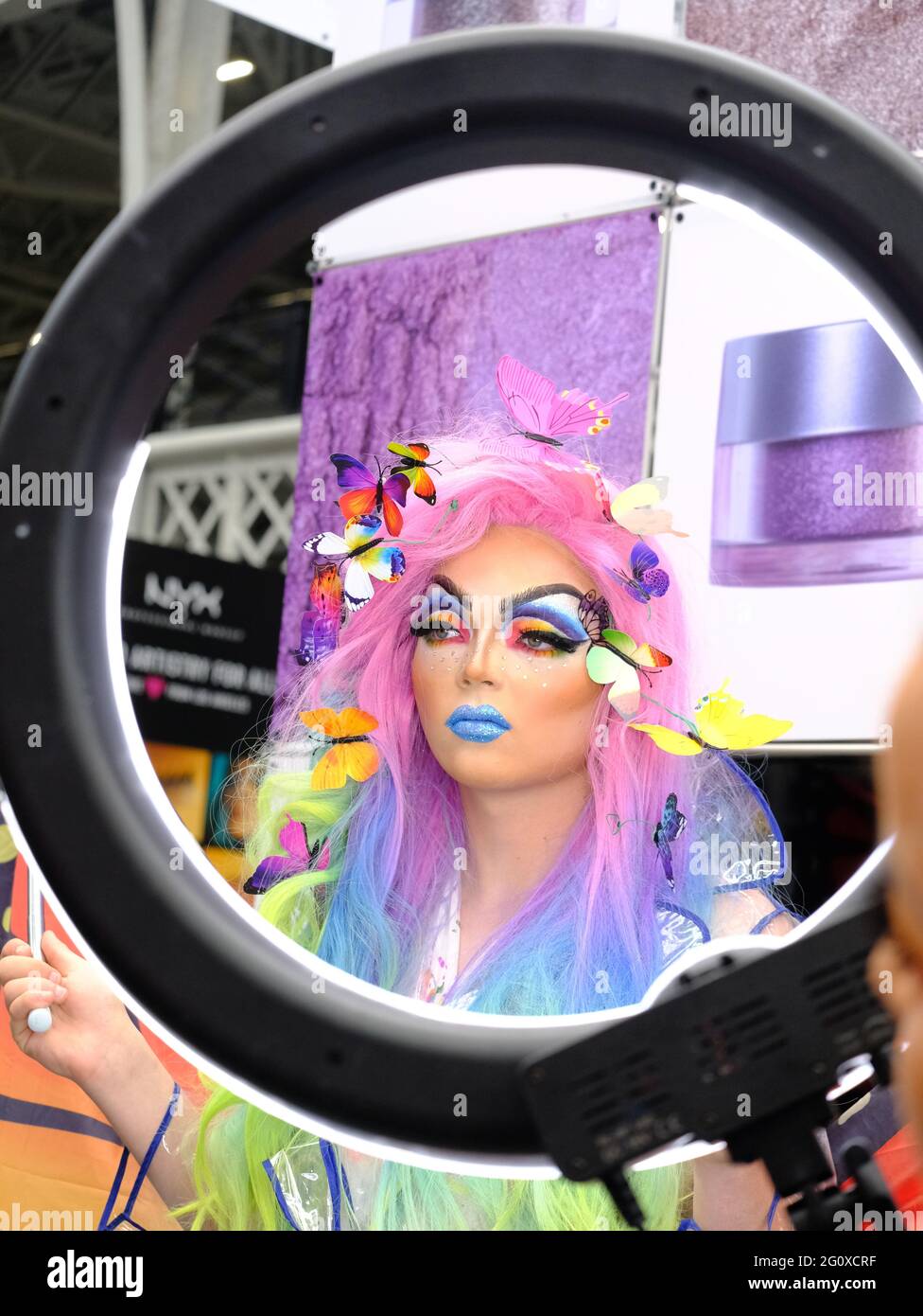 A model shows off a finished 'drag queen' inspired makeup look during