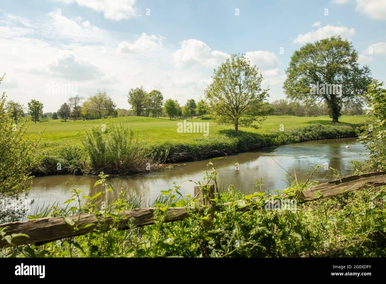 Landscape, fence, river Wey and Wisley golf course in bright Surrey spring sunshine Stock Photo