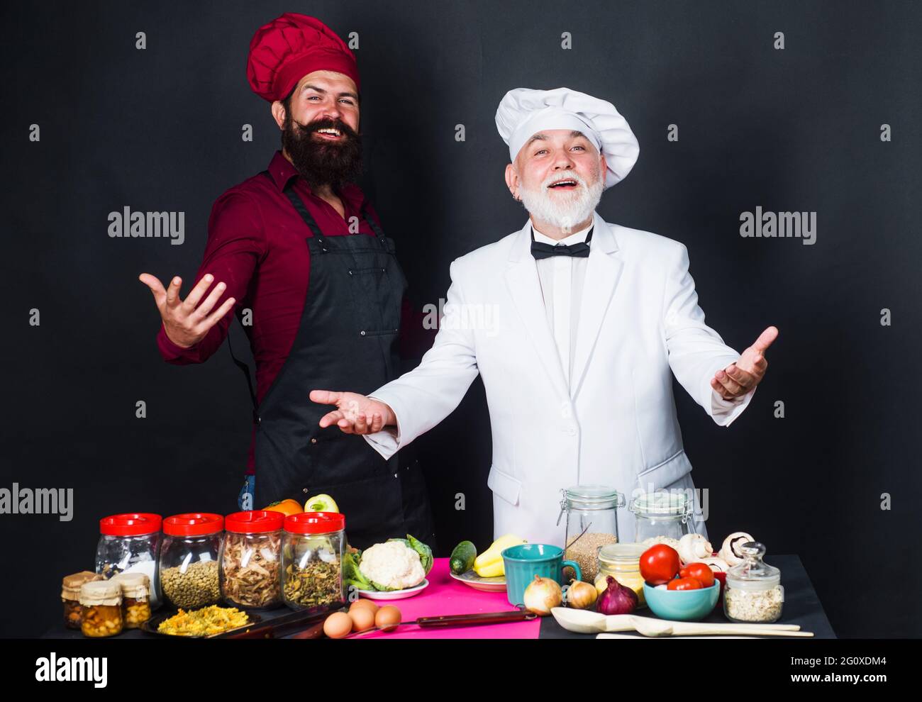 Kitchen battle. Two bearded professional chefs in uniform. Cooking time. Stock Photo