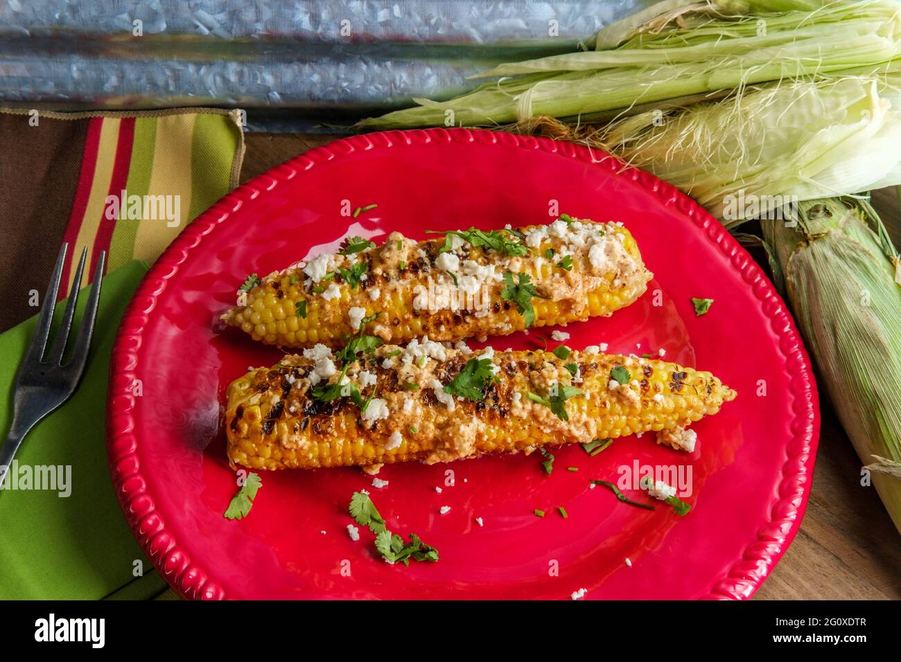 Mexican street corn also known as elote served with chili mayonnaise and cotija cheese Stock