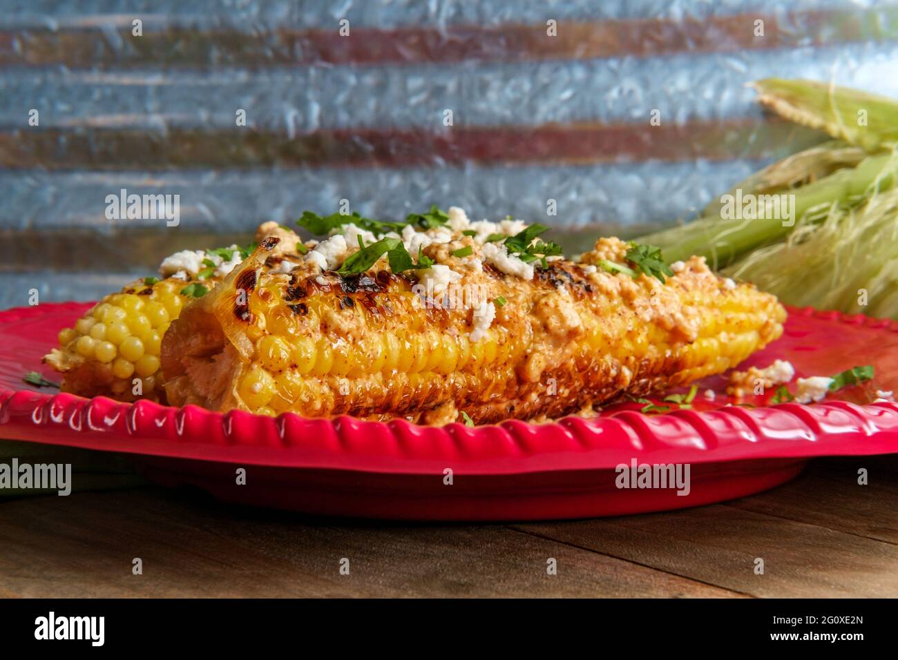 Mexican street corn also known as elote served with chili mayonnaise and cotija cheese Stock