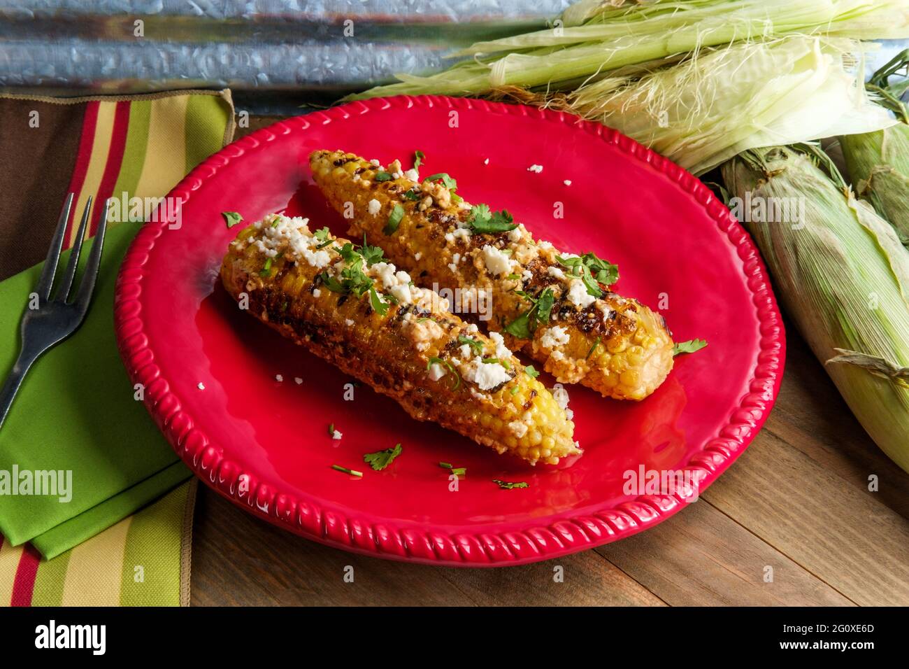 Mexican street corn also known as elote served with chili mayonnaise and cotija cheese Stock