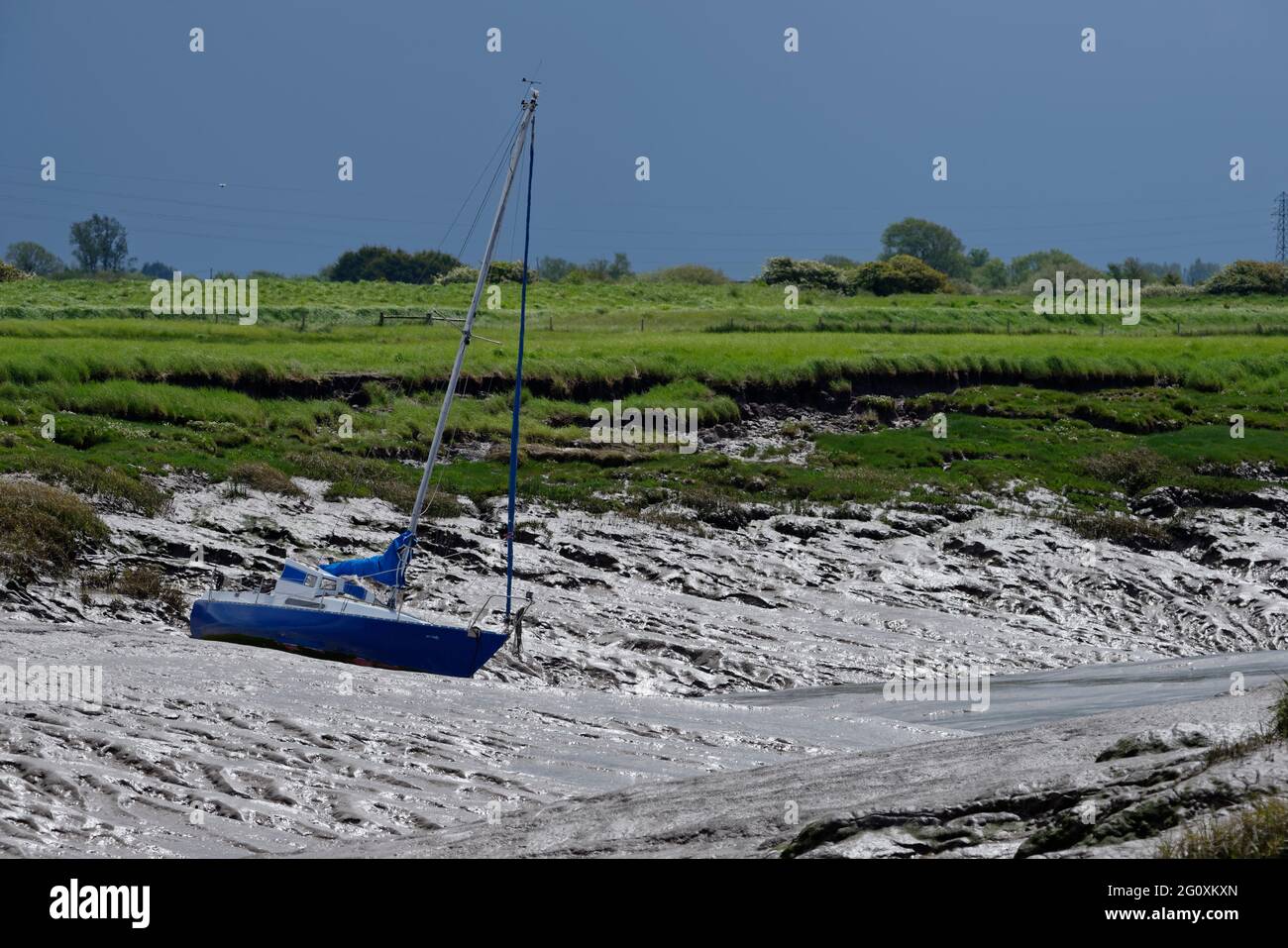 Yacht in small creek at low tide, Uphill, Somerset Stock Photo