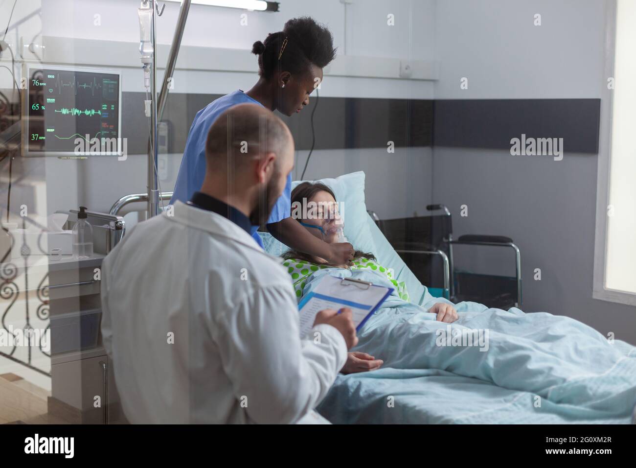 Clinical team monitoring sick woman putting oxigen mask monitoring health respiratory during