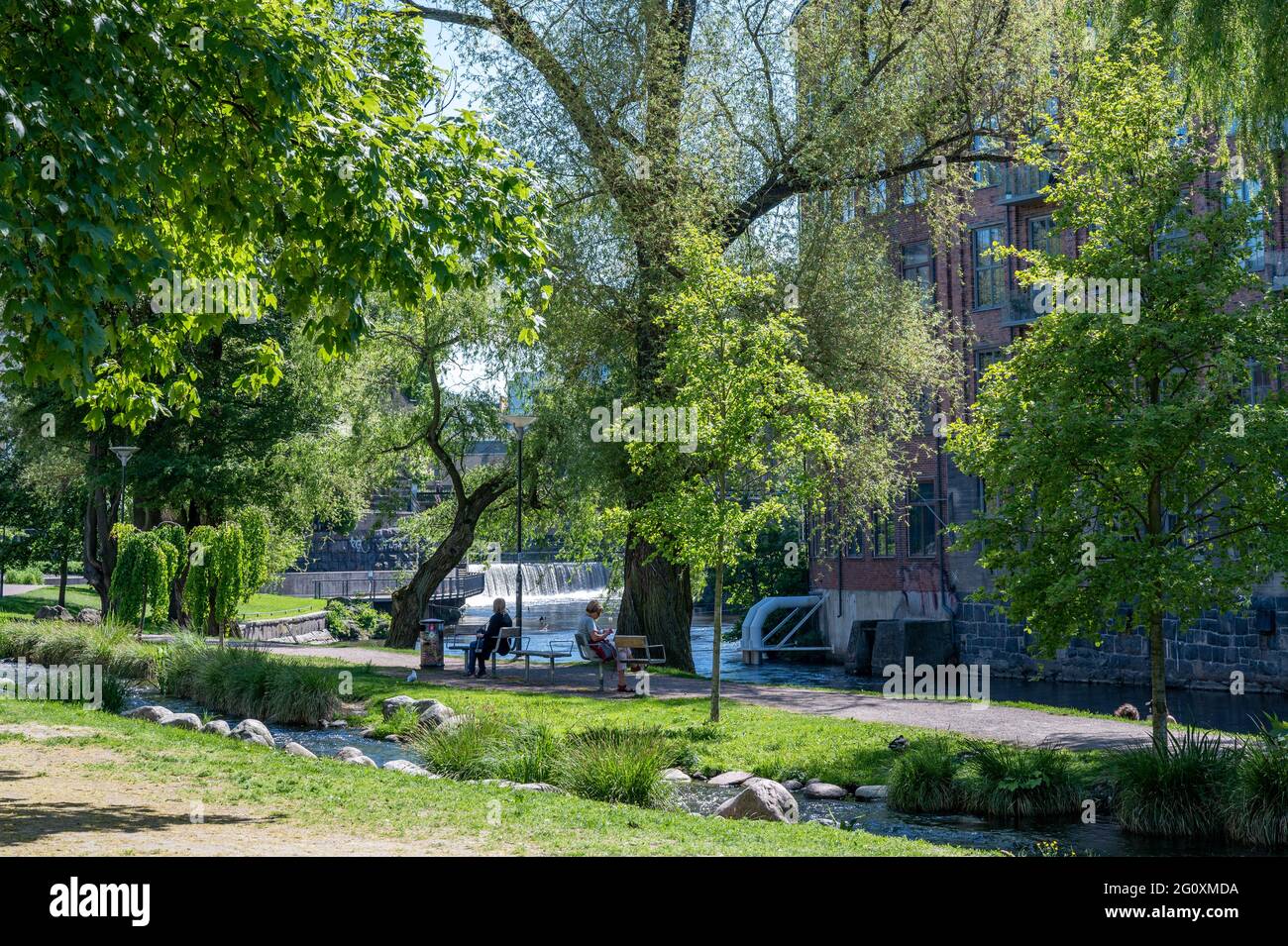 People relax in waterfront park Stromparken during early summer in Norrkoping, Sweden. Norrkoping is a historic industrial town. Stock Photo