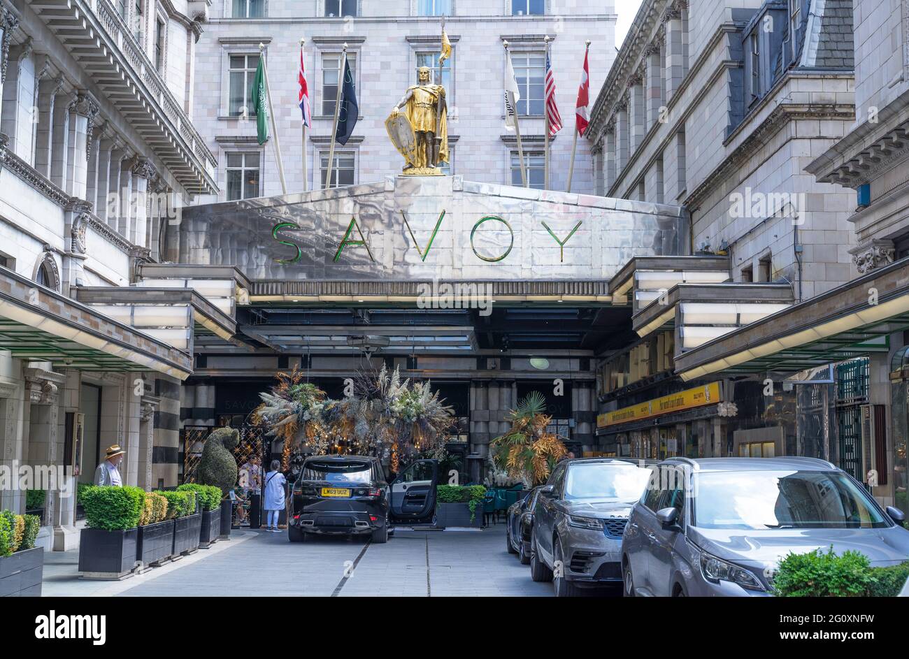 The Savoy Hotel entrance with tourists arriving in cars during the day. London Stock Photo