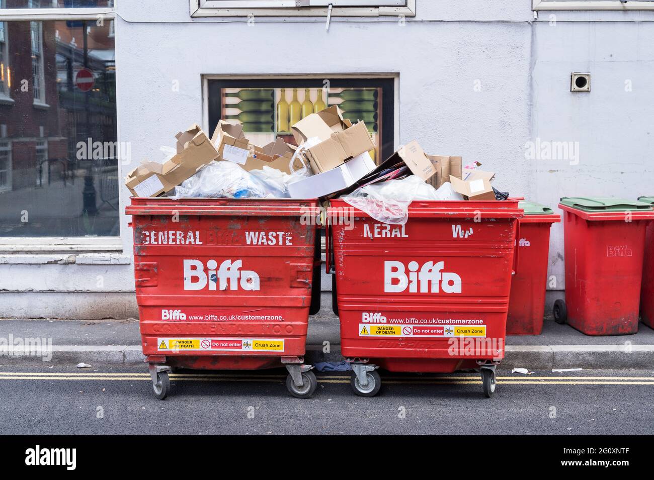 Red Biffa bins overflowing with rubbish on the street. London Stock Photo