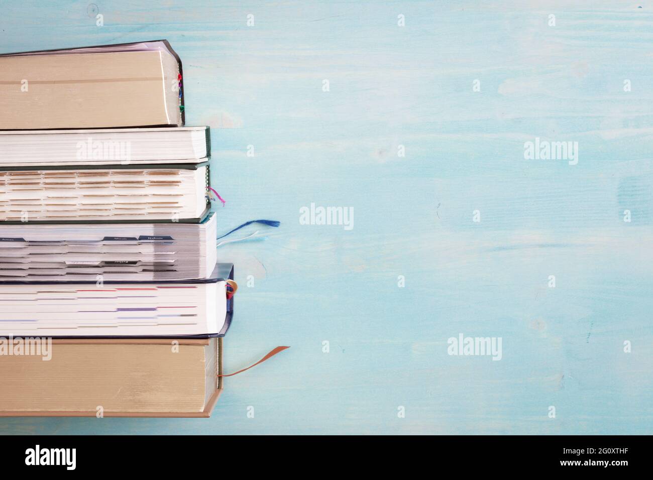 border of stack of books on blue wood background with copy space Stock Photo