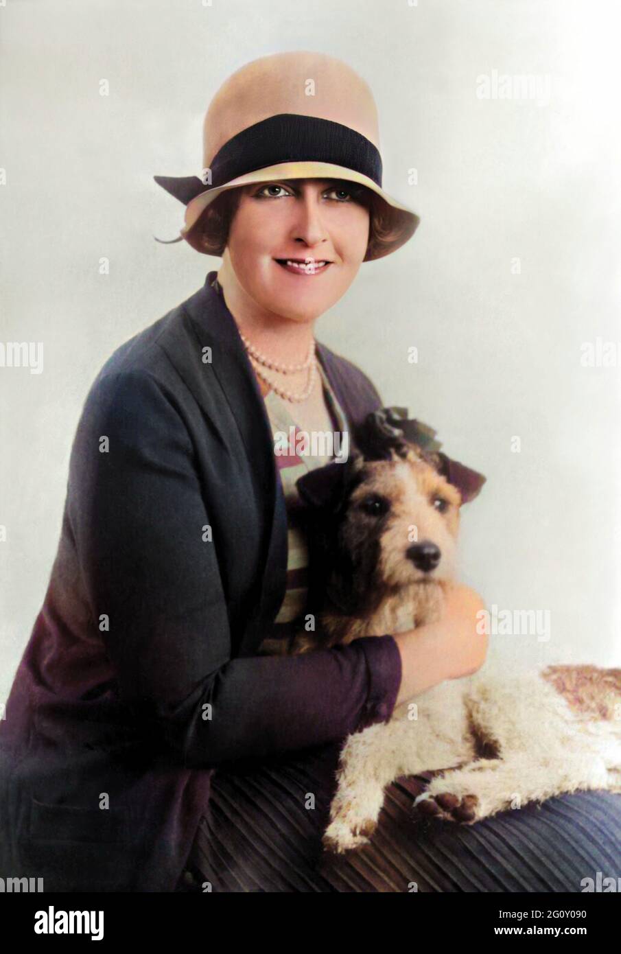 1928 ca, LONDON , GREAT BRITAIN : The british woman writer detectives stories  AGATHA CHRISTIE ( 1891 - 1976 ) with his pet dog  . Unknown photographer. DIGITALLY COLORIZED .- SCRITTRICE libri GIALLI - SCRITTRICE - SCRITTORE - LETTERATURA - triller - detective stories - LITERATURE - letterato - ritratto - portrait - triller - romanzo giallo - romanzi - pearls necklace - collana di perle - perla  - jewellery - jewels - gioiello - gioielli  - SMILE - SORRISO - HISTORY - FOTO STORICHE - CANE - animale domestico - FASHION - MODA FEMMINILE - 900's - '900 - NOVECENTO - hat - cappello - ANNI VENTI - Stock Photo
