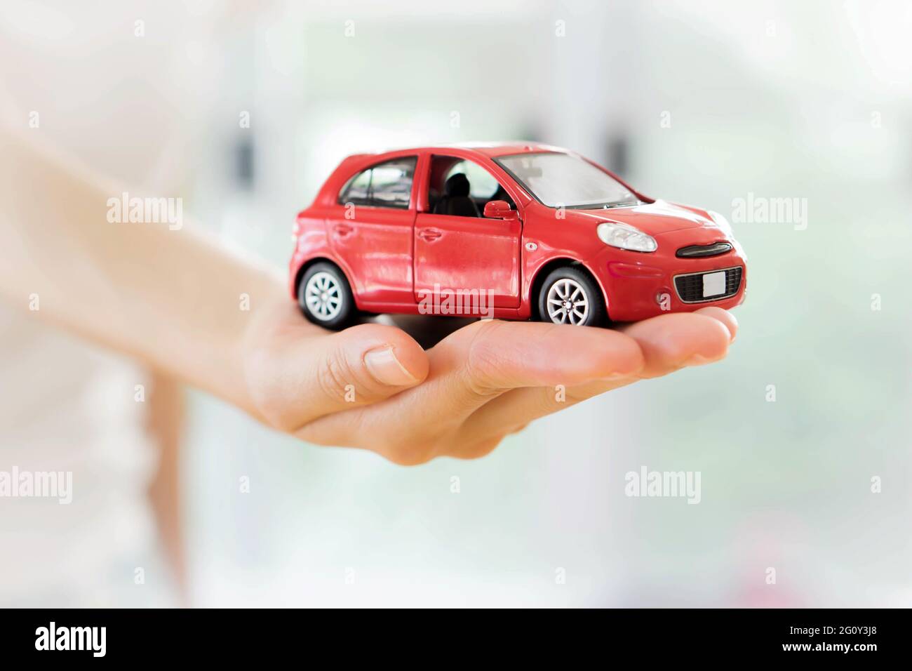 Hand with a red car. Dealership concept Stock Photo Alamy