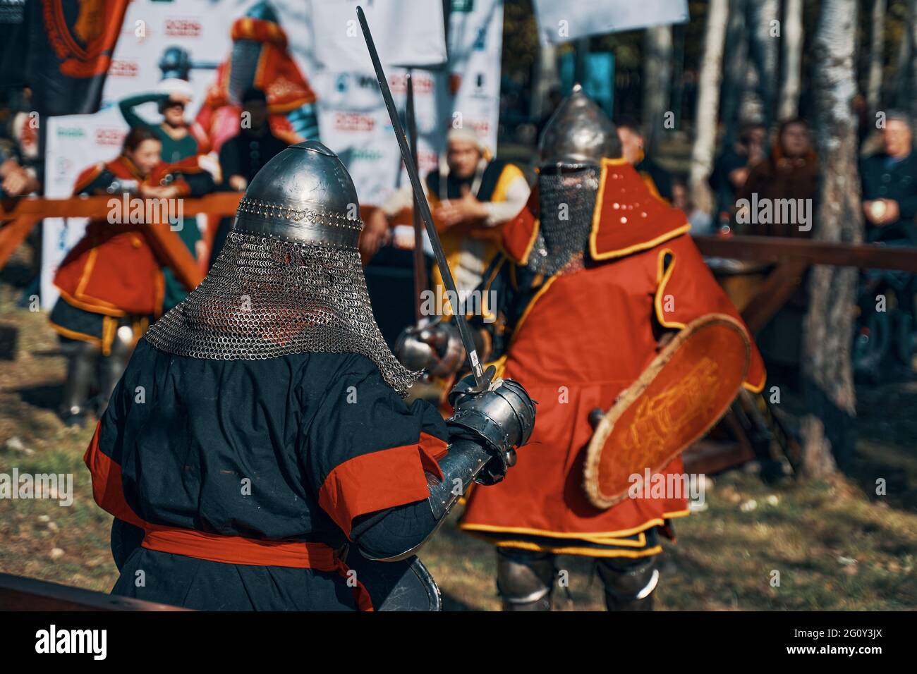 Knights fight with swords and shields in front of the public