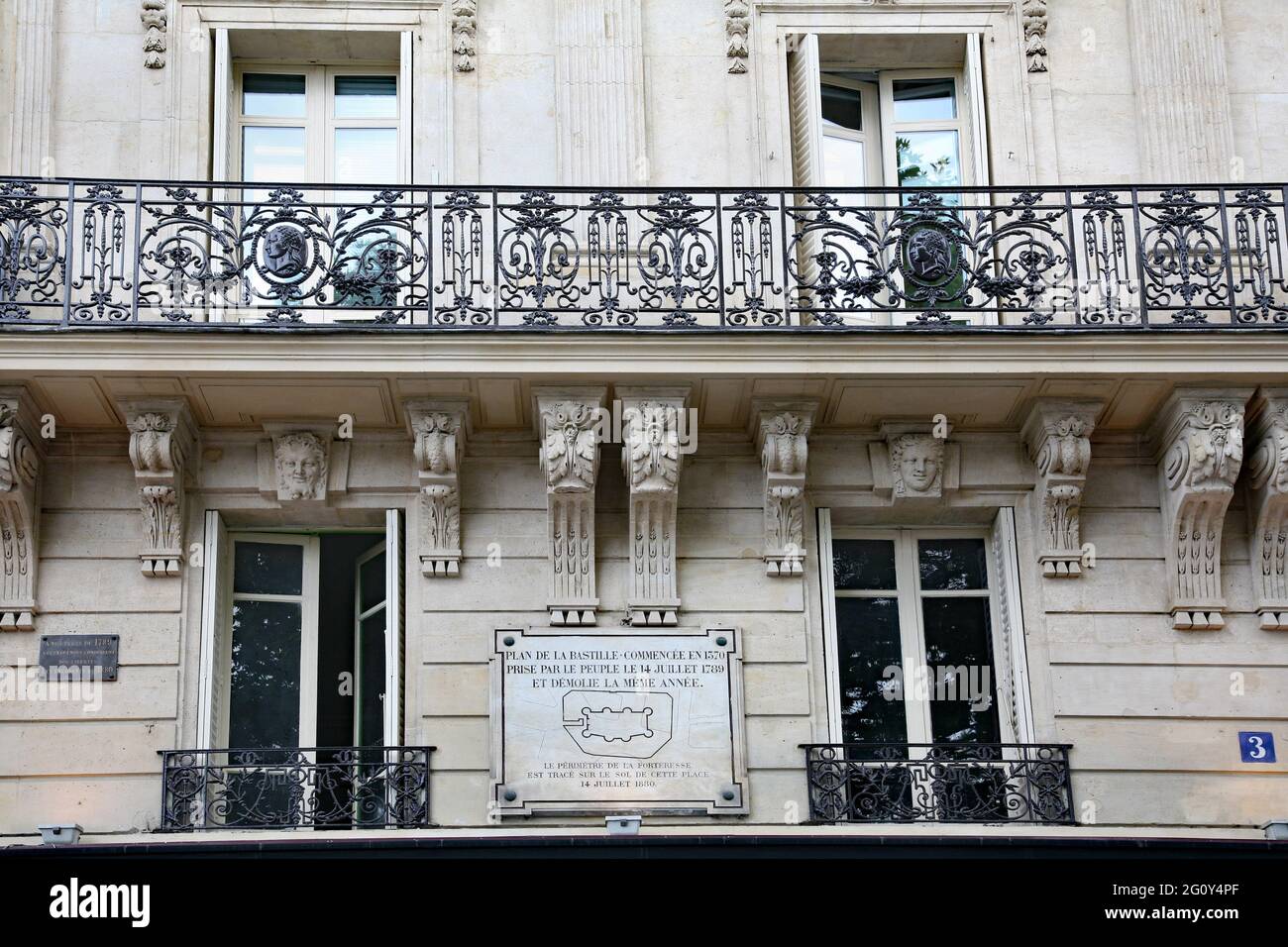 Paris, France - July 7, 2010:  Apartment building overlooking the former site of the Bastille prison fortress, with a plaque showing its outline. Stock Photo
