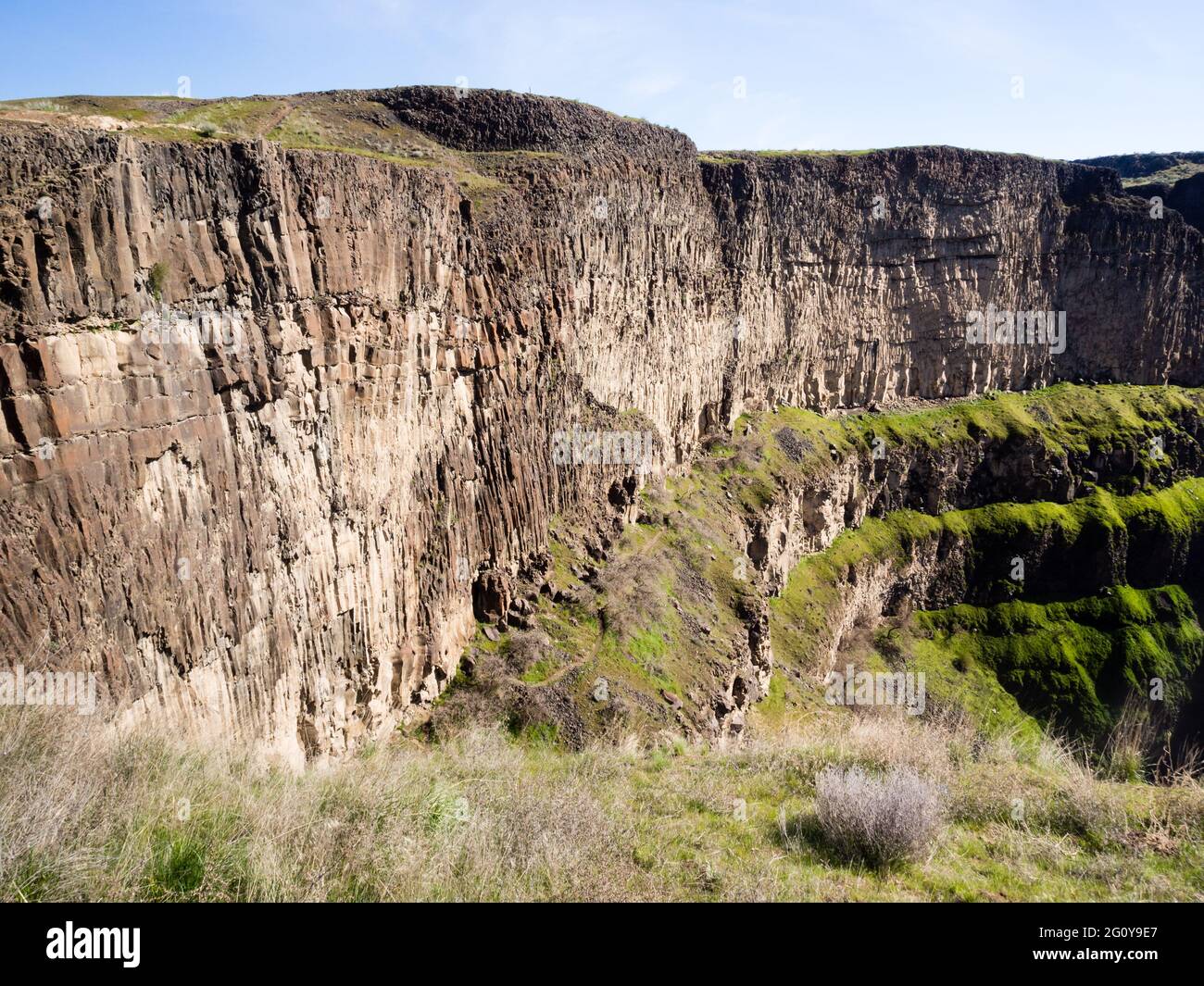 Basalt column rock formations at Palouse Falls, Washington state, USA, with hiking trail running along the canyon wall Stock Photo