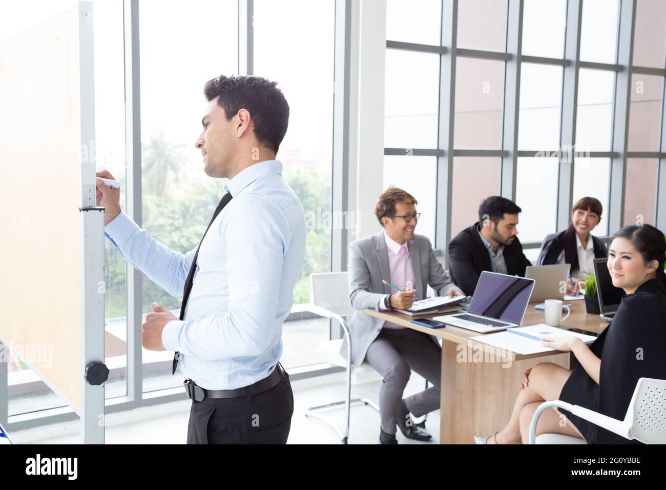 Business executive delivering a presentation to his colleagues during ...