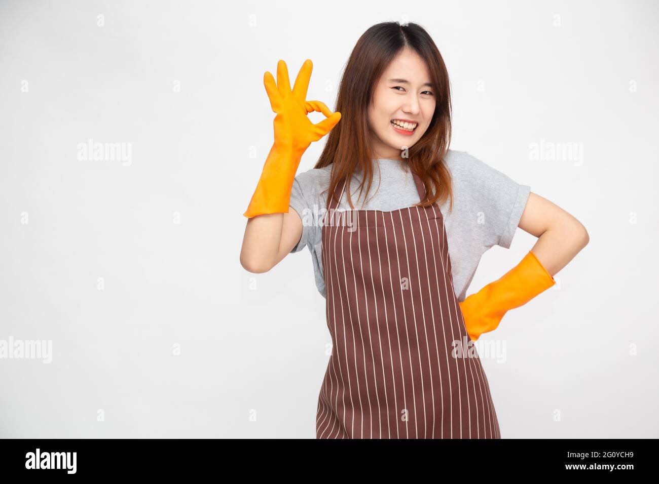 Portrait of young Asian woman wearing orange rubber gloves for hands ...