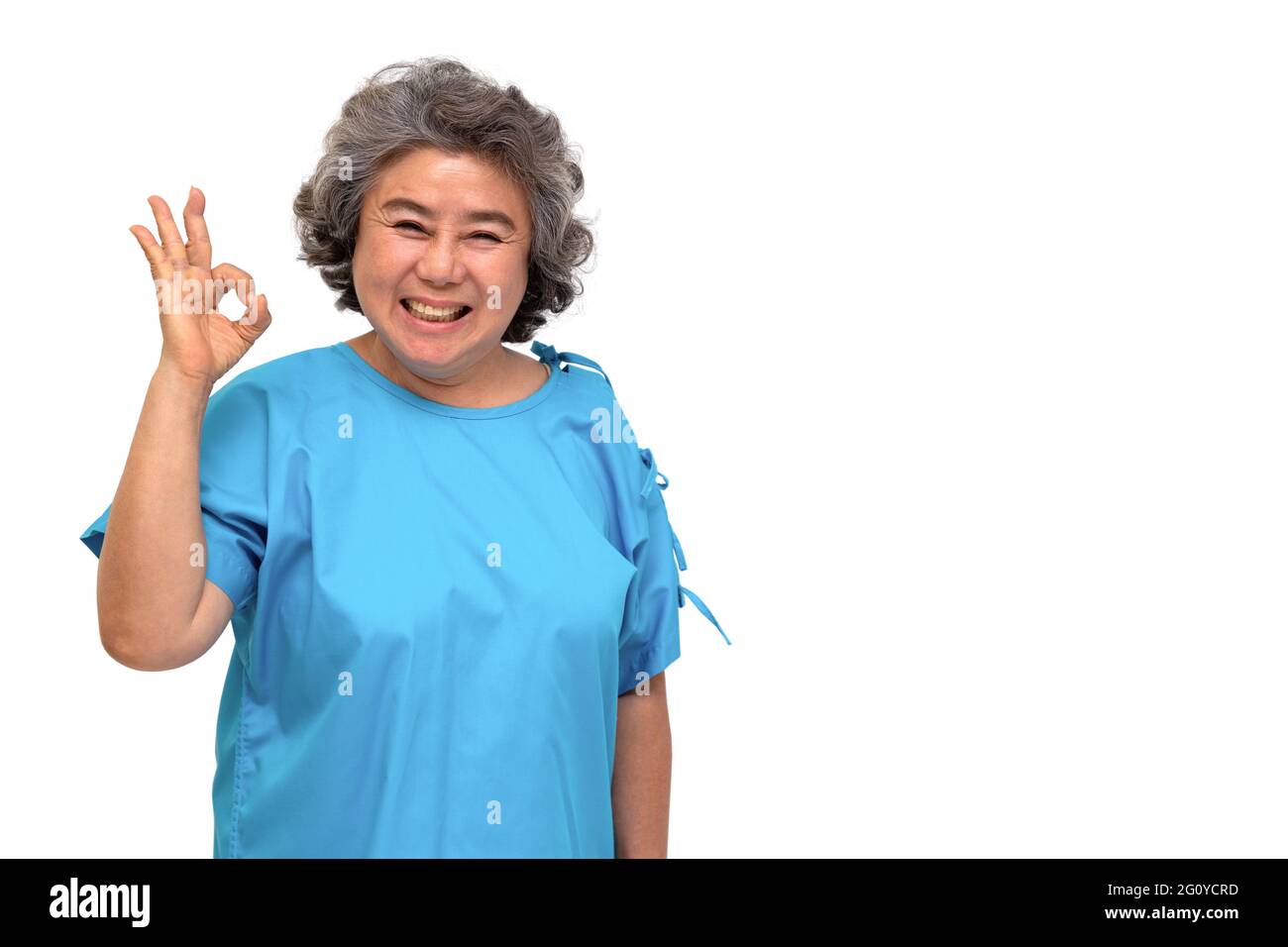 Portrait of happy senior asian woman patient showing hand ok and looking at camera isolated on white background, Older female feeling positive and enj Stock Photo