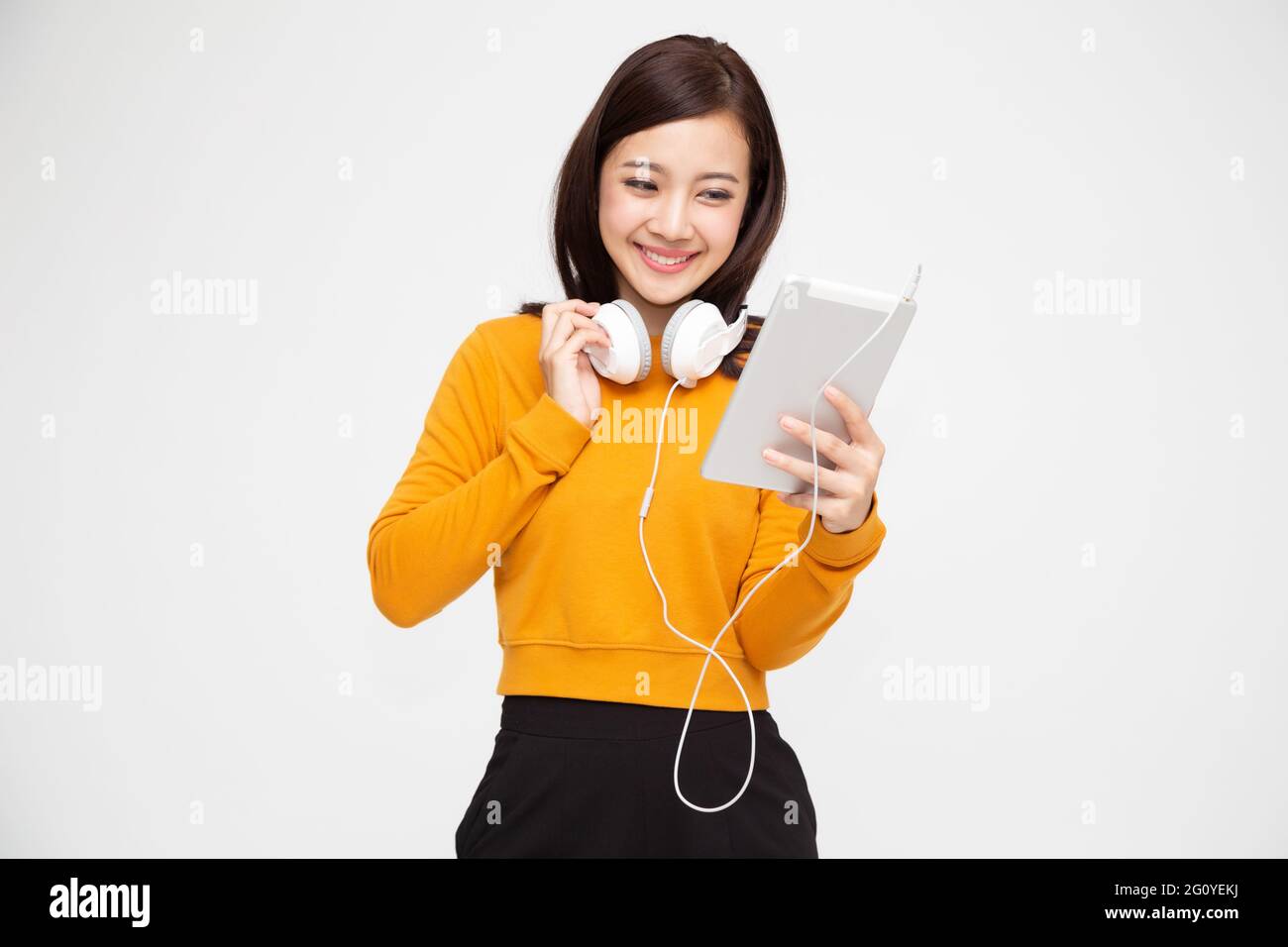 Beautiful young Asian woman with headphones listening to music in ...
