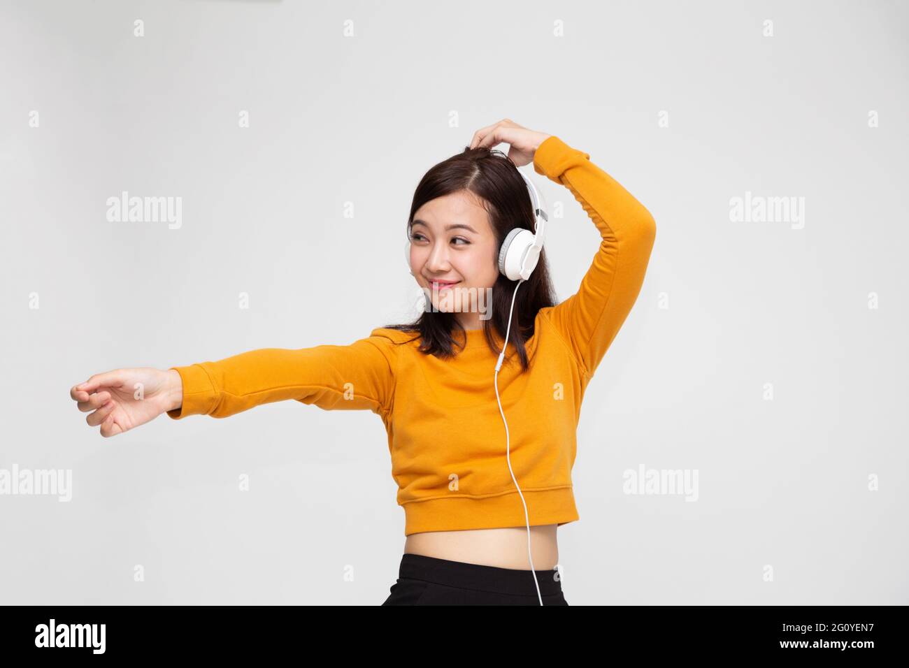 Beautiful young Asian woman with headphones listening to music in ...