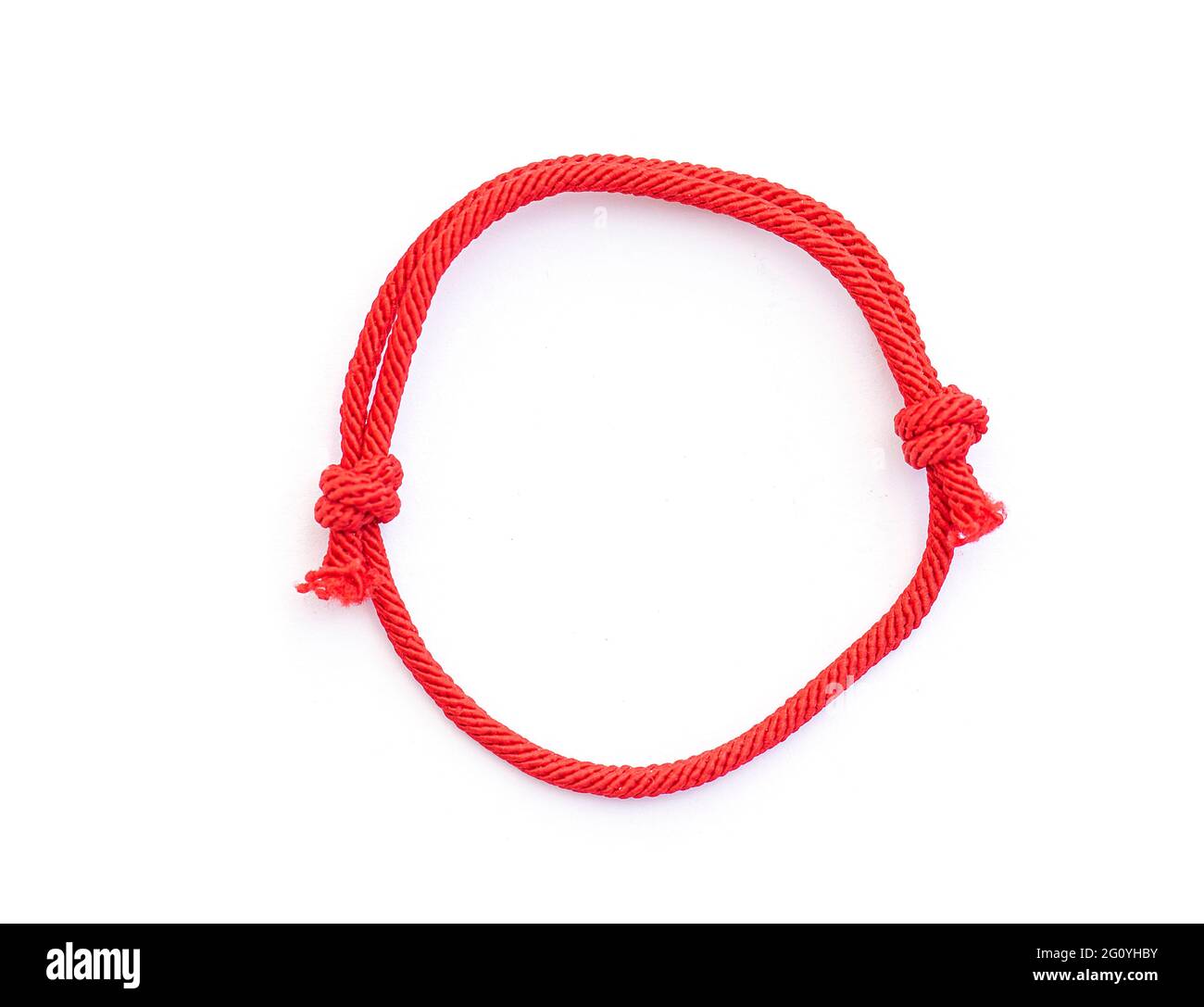 Red thread, string as amulet for wrist isolated on white. Red bracelet with knots. Top view. Stock Photo