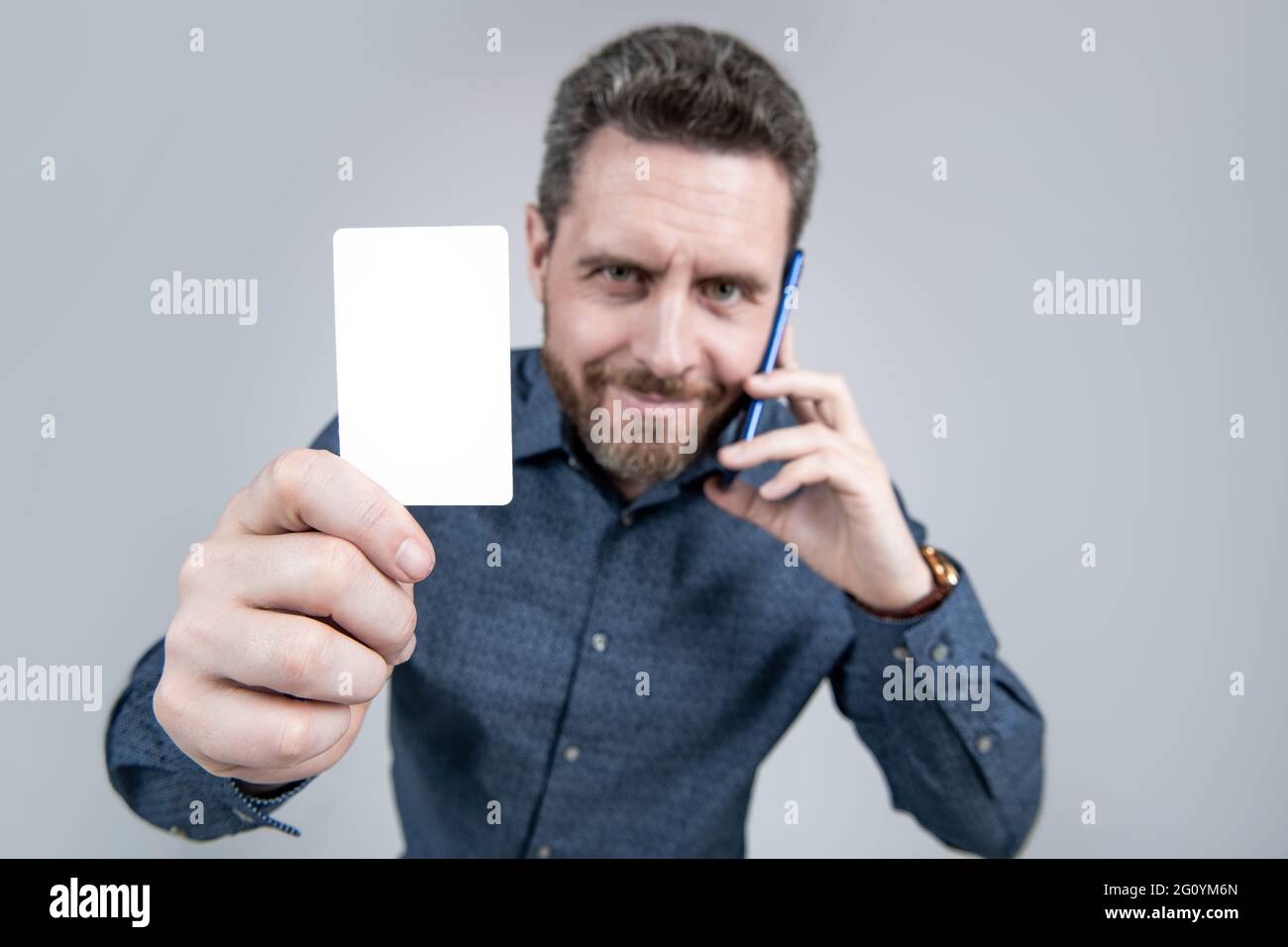 credit card in hand of business man speaking on phone, selective focus, copy space, contact me. Stock Photo
