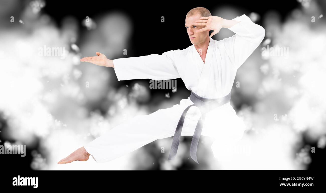 Compostion of caucasian male karate fighter on black background with