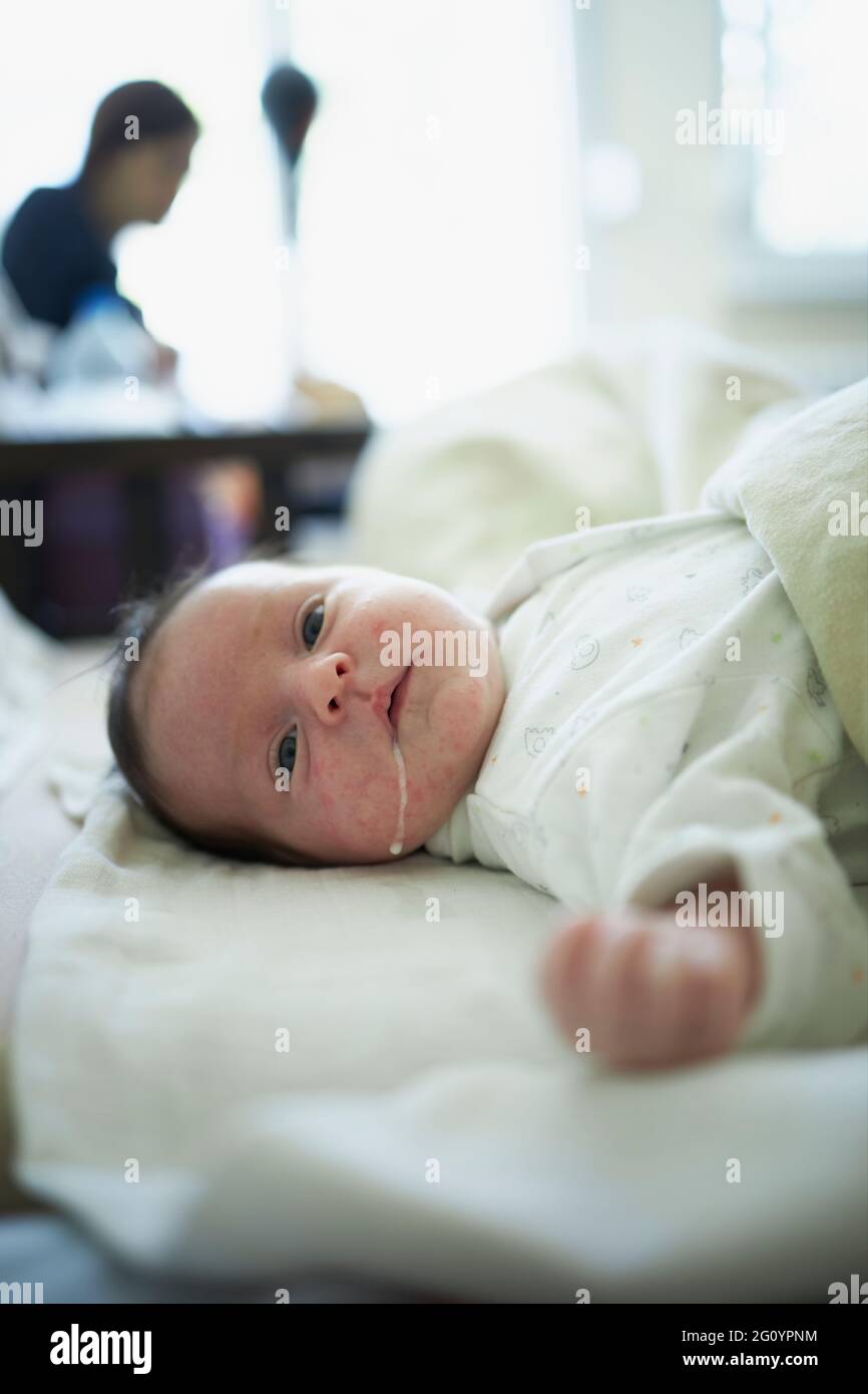 Cute baby regurgitating small amount of milk Stock Photo