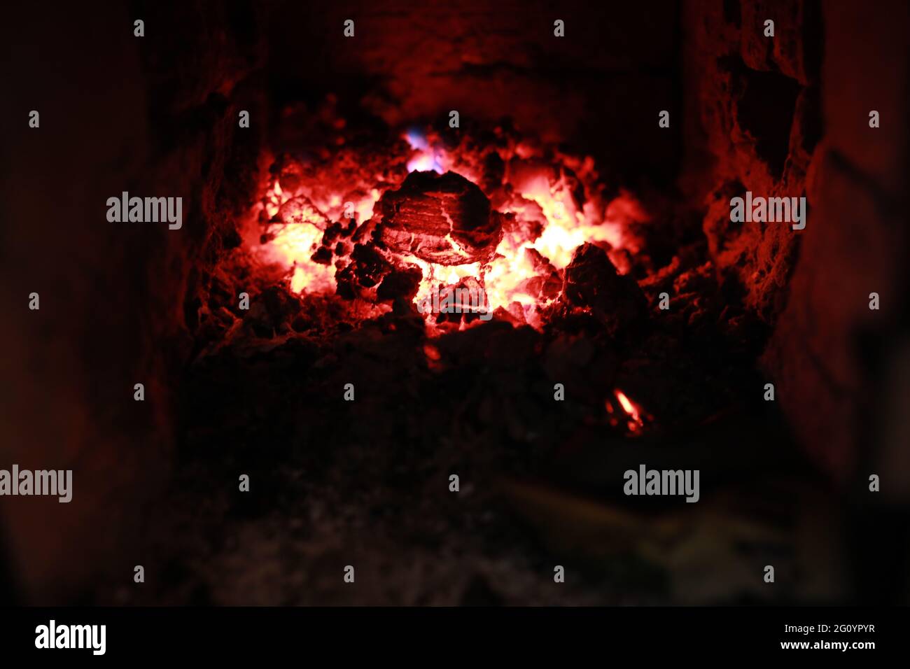 heated stove in the house with red coals and fire Stock Photo