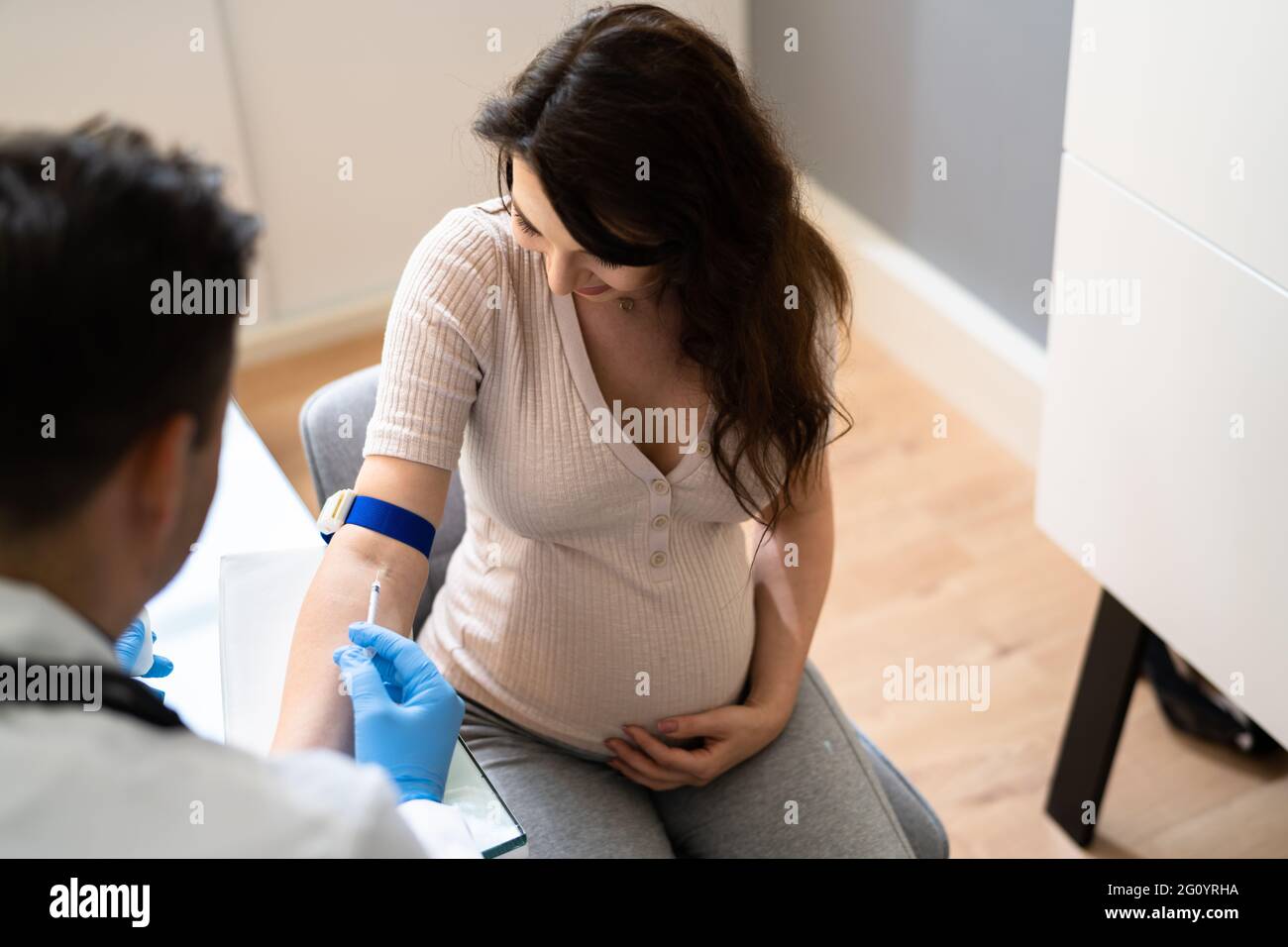 Prenatal Screening. Doctor Drawing Blood Sample From Pregnant Woman Stock Photo