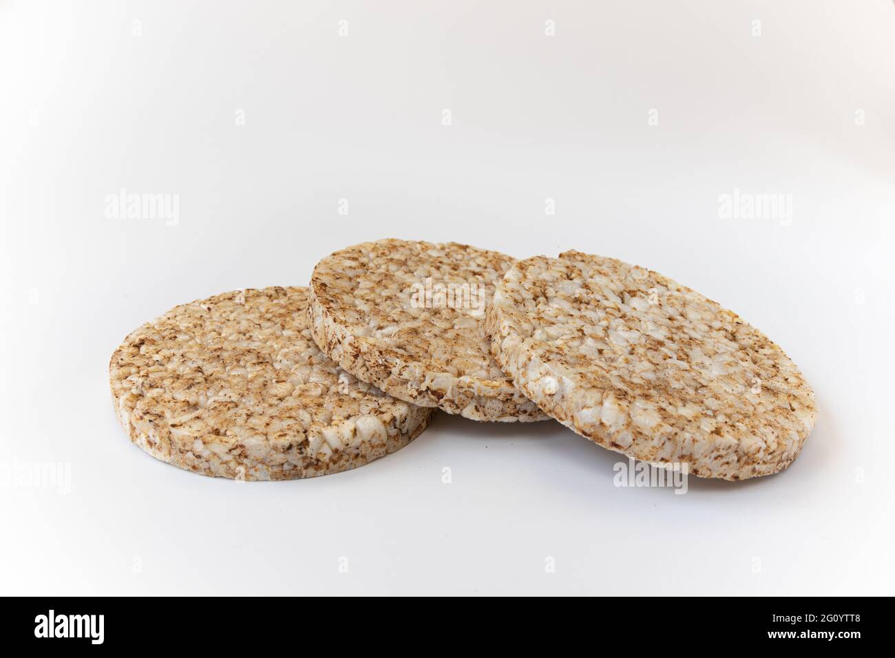 crunchy rice cakes on white background, three puffed whole grain