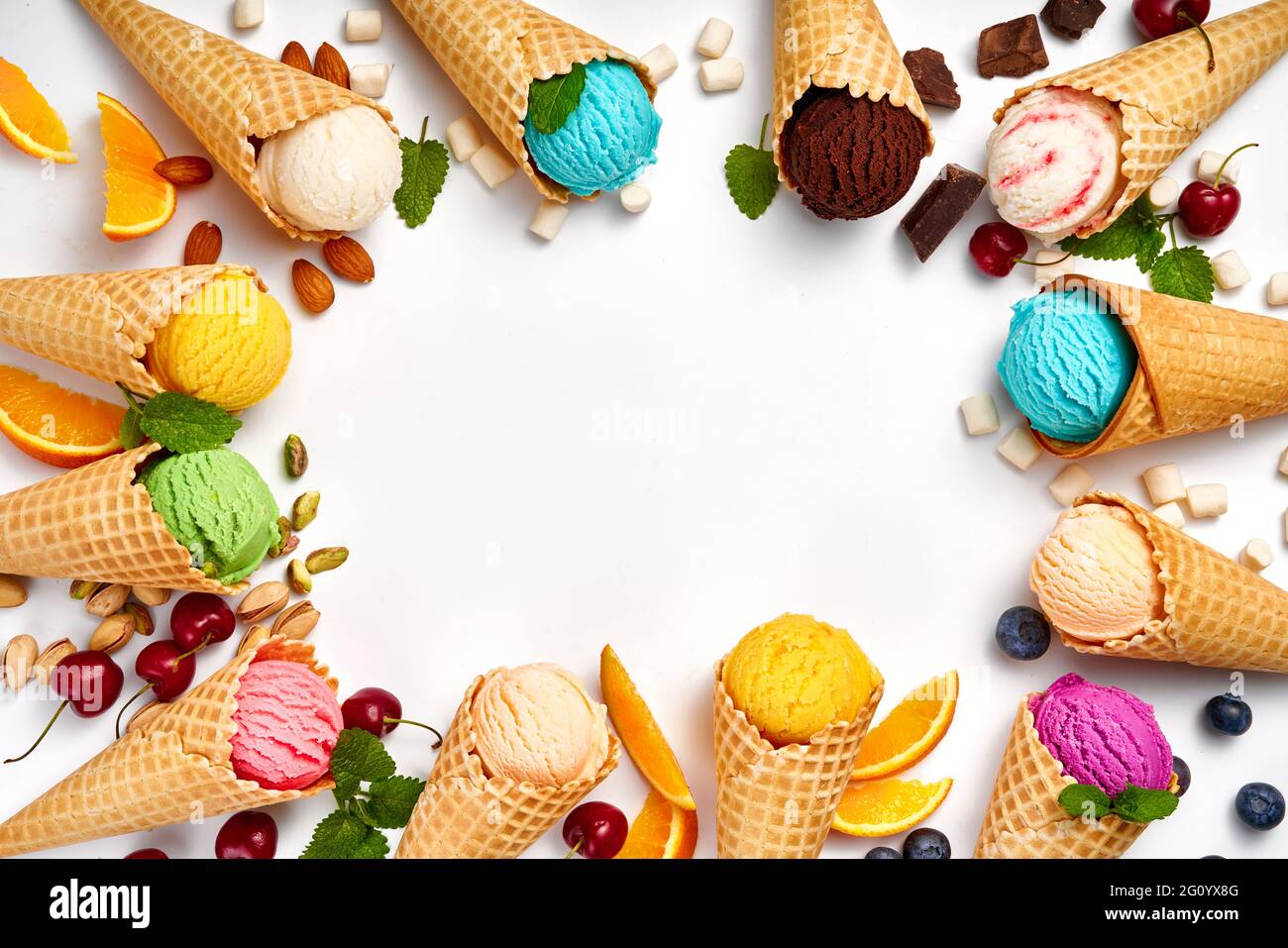 Assorted of ice cream in cones on white background. Colorful set of ice cream of different flavours. Ice cream isolated with nuts, fruits and berries. Stock Photo