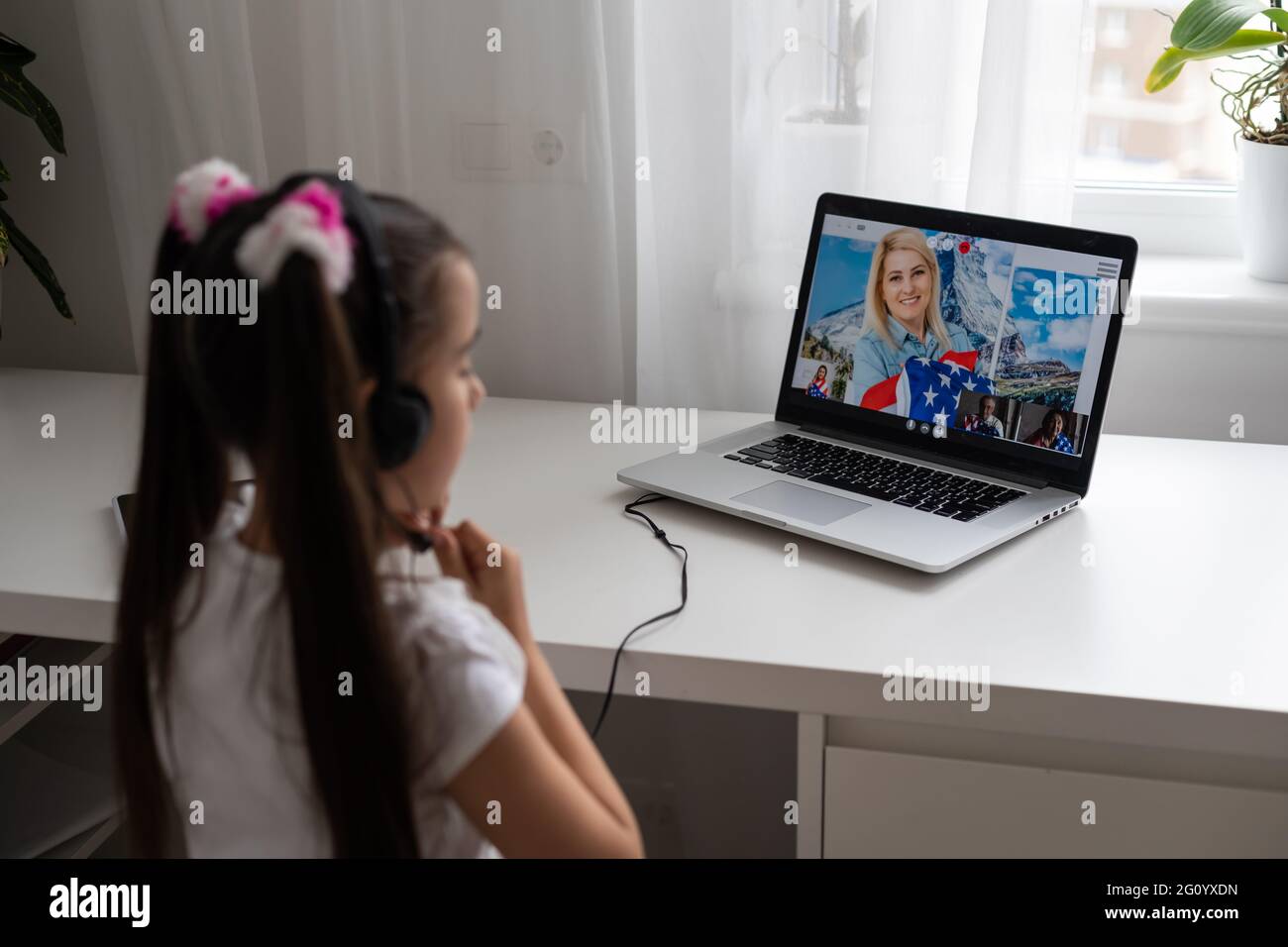 Little girl studying online using her laptop at home Stock Photo - Alamy