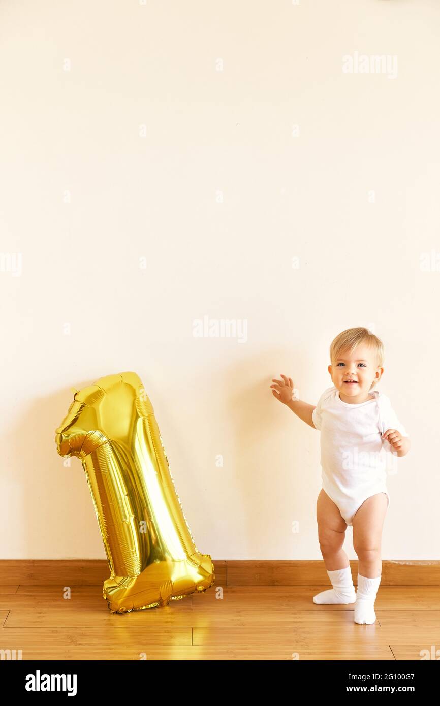 Little cute girl stands near the inflatable number one Stock Photo - Alamy