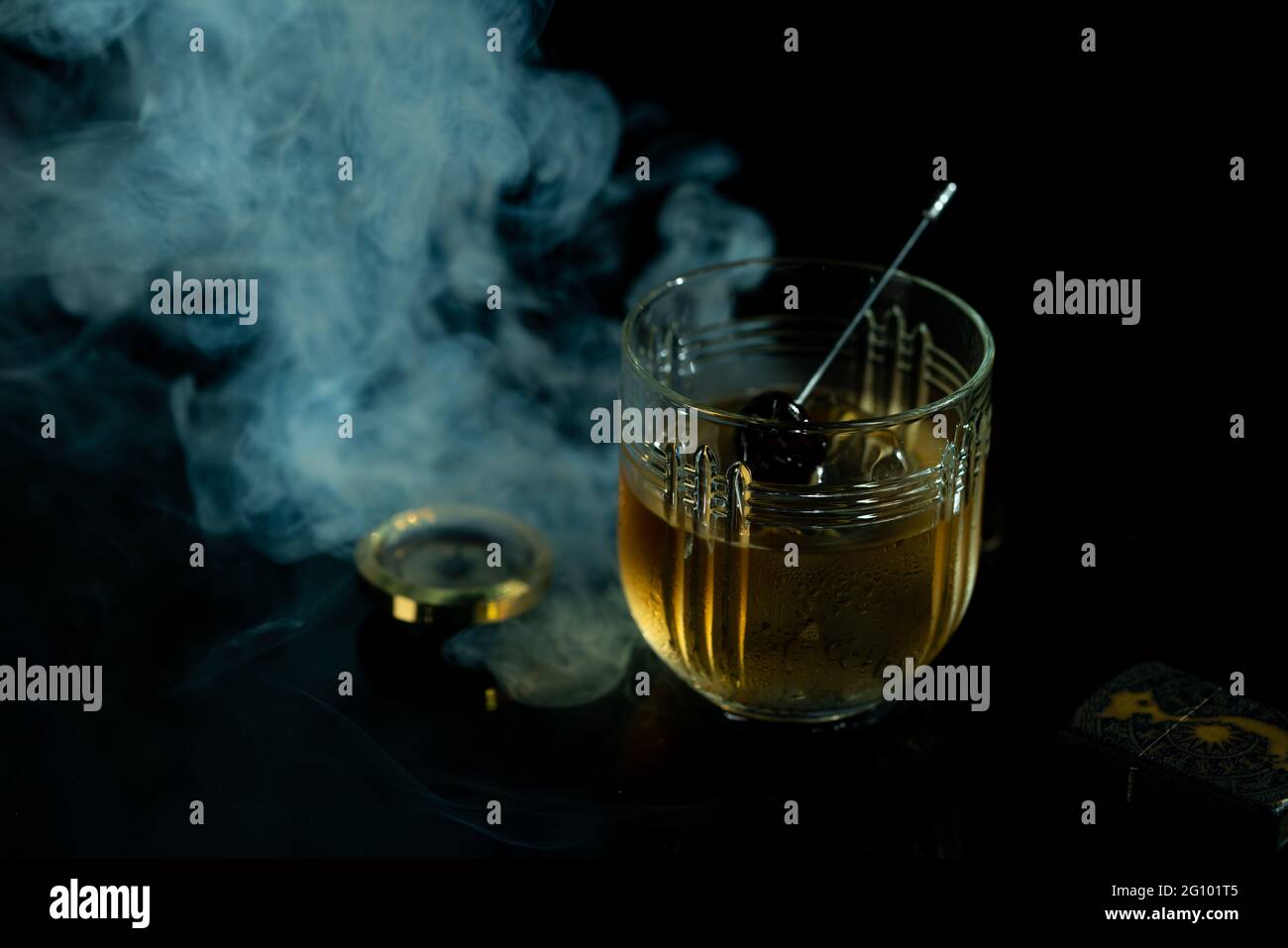Luxury cocktail glass and cherry on black background with smoke. High