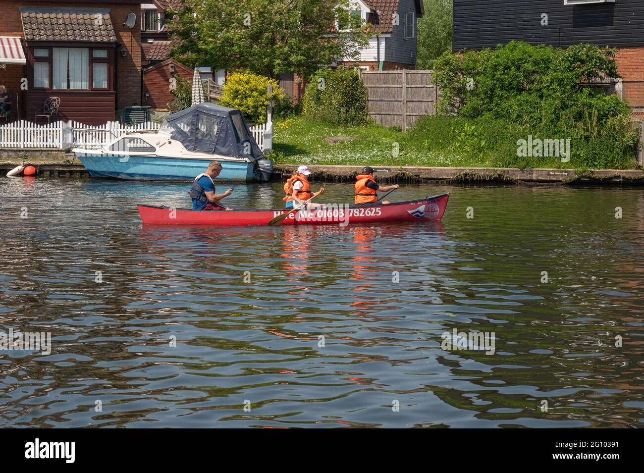 A canoe for hire being used on the river bure at wroxham with four