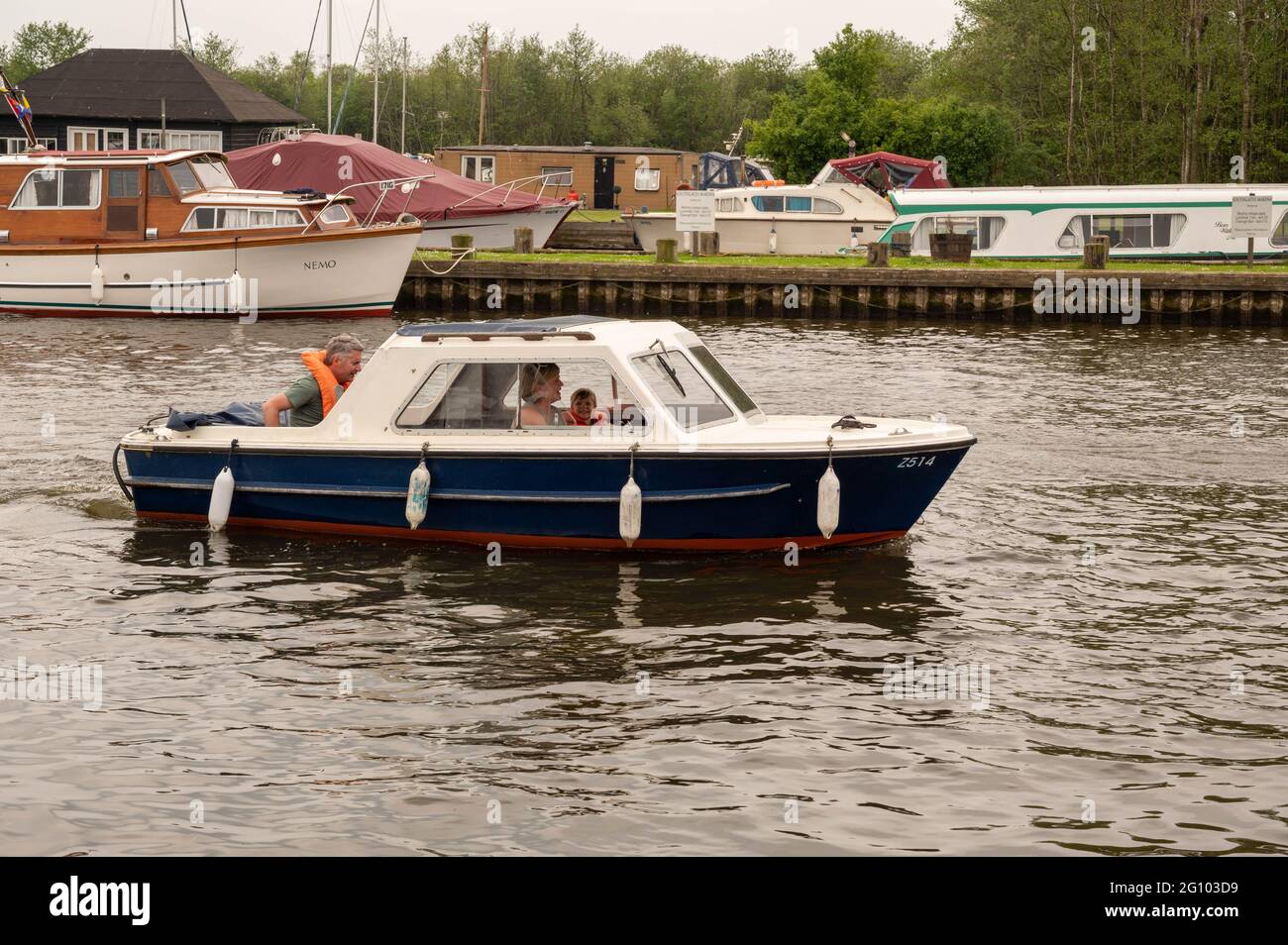 A day hire boat on the norfolk Broads with a family of three onboard Stock Photo