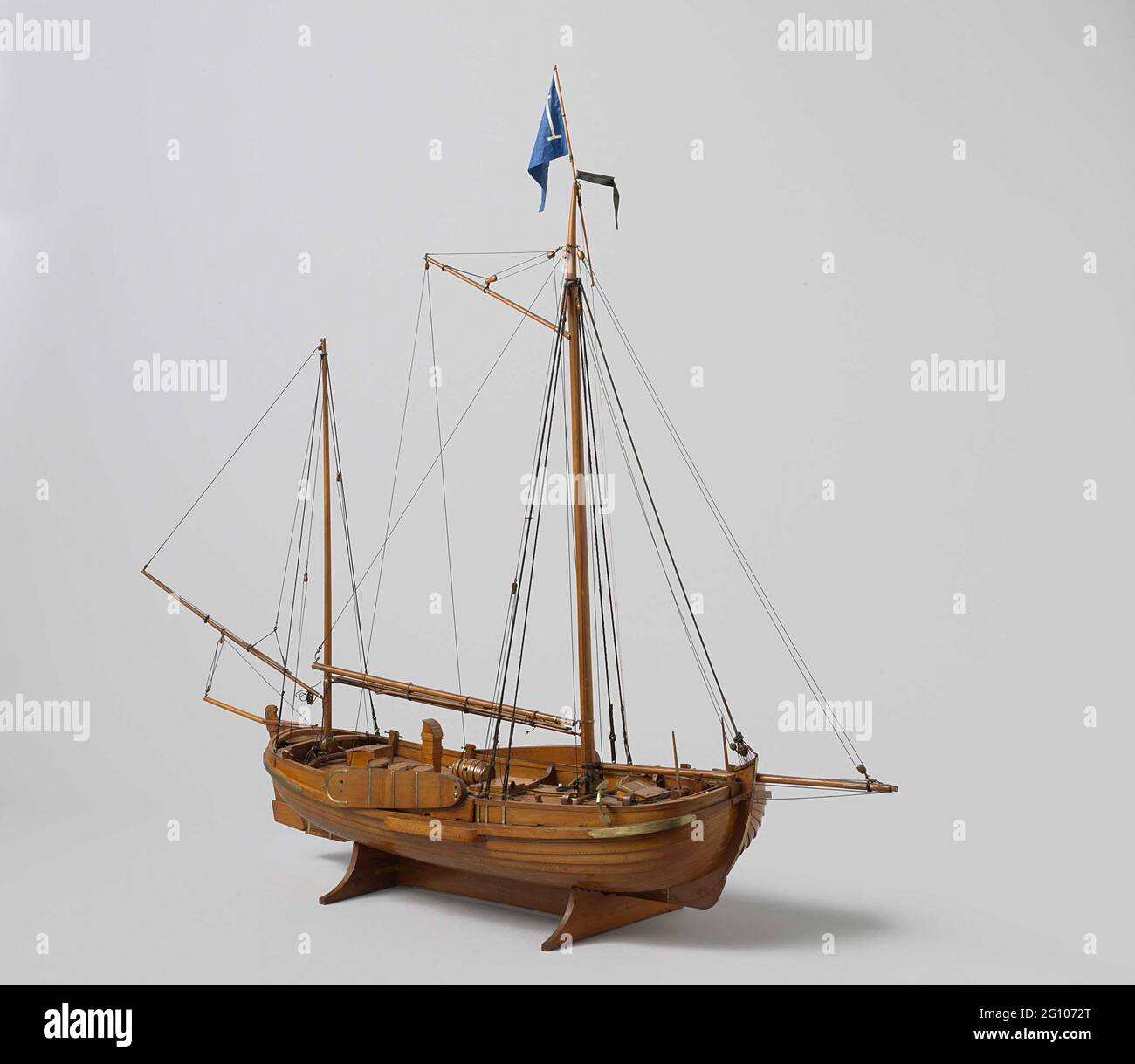 Model of a Pilot Vessel. Witnessed out hollow block model of a two-timed flat bottom. Parts of the deck can be taken to show the shooting deck. Round bow and stern, strongly falling stern; Broad stir with so-called, decorated stirring head and wooden helm stick. The seam runs to both ends, a barque, two swords. The model is equipped with two anchors, a roasting pill, four water barrels, a chimney for the galley, two oars, two pumps, two ranges and a greater hatch. The rig is an elastic yielding rig without sailing, with bow mad and parrot bowl. Scale 1:20 (according to Obeenen). Stock Photo
