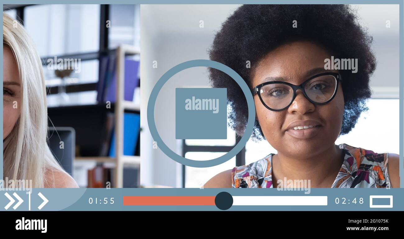 Composition of two businesswomen having video call on video playback interface screen Stock Photo