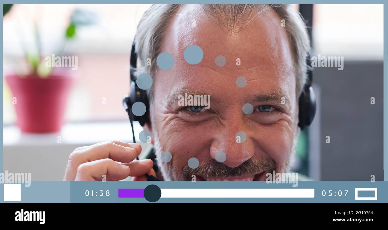 Composition of businessman talking on headset on video playback interface screen Stock Photo