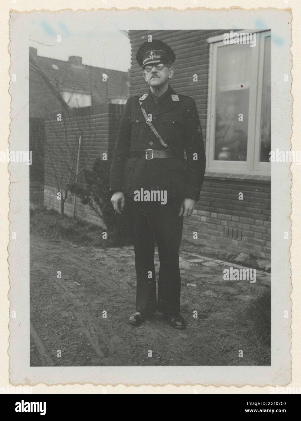 Portrait of a member of the WA; NSB. Portrait of a member of the WA. Fut out, standing in front of a house. On his collar a distinctive with two stars: companion, the lower frame. Hat with the Wolfsangel, on his left sleeve. The triangular emblem of the NSB. Belt diagonally over the chest. It is an older man with glasses and mustache. The inscription on the back mentions that it is a member of the country guard, founded at the end of 1943. Stock Photo
