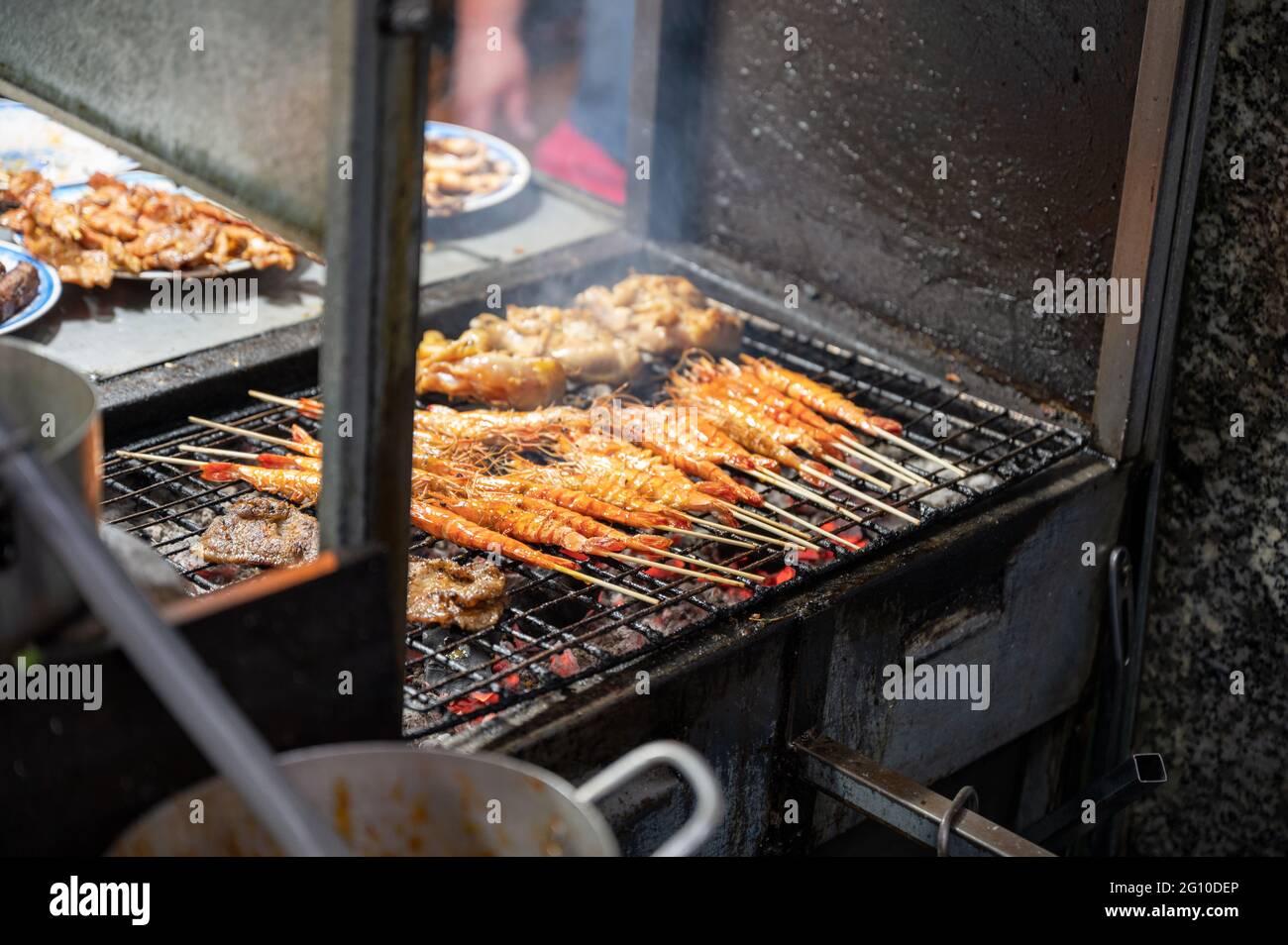 Shrimp skewers with seasoning grilling on charcoal stove Stock Photo