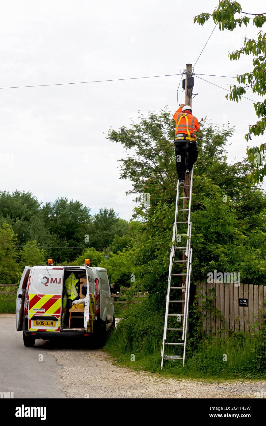 Engineer installing broadband connection in village, England UK Stock