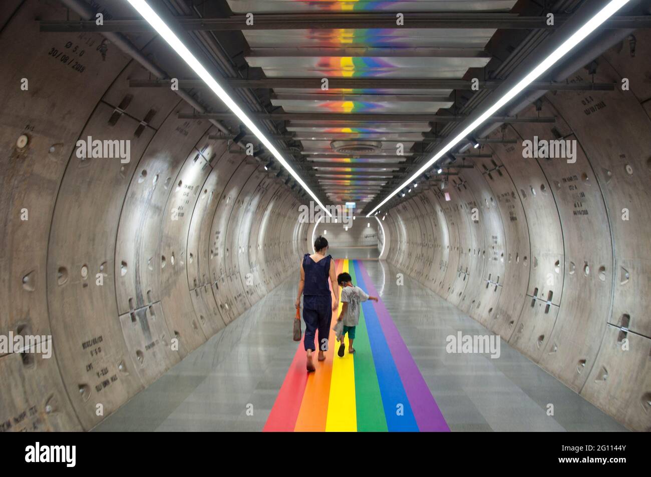 Bangkok, Thailand. 04th June, 2021. A woman and a kid walk along a rainbow flag decorated in the tunnel of the basement of Samyan Mitrtown shopping mall.Samyan Mitrtown, a mixed-use shopping, office, residential and leisure development celebrated the LGBTQ Pride Month 2021 by decorated the floor at the entrance and the tunnel of the mall with the huge and long rainbow flag. 'Samyan Mitr Proud 100% Love' in Bangkok, Thailand. Credit: SOPA Images Limited/Alamy Live News Stock Photo