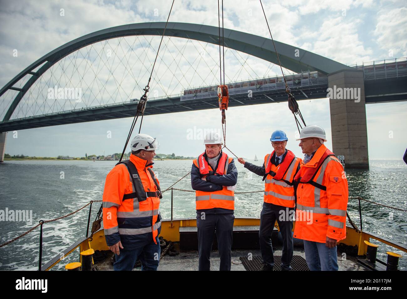 Fehmarn, Germany. 04th June, 2021. Uwe Fresenborg (l-r), Project Manager Celle Well Construction, Bernd Buchholz (FDP), Minister of Economics, Transport, Labour, Technology and Tourism of Schleswig-Holstein, Bernd Rothe, Division Manager Deutsche Einheit Fernstraßenplanungs- und -bau GmbH, and Bernd Homfeldt, Head of Major Project Rail Link of the Fehmarn Belt Fixed Link, stand on the quarterdeck of a boat during the crossing from Fehmarn to the drilling platform between the island and the mainland. Credit: Gregor Fischer/dpa/Alamy Live News Stock Photo