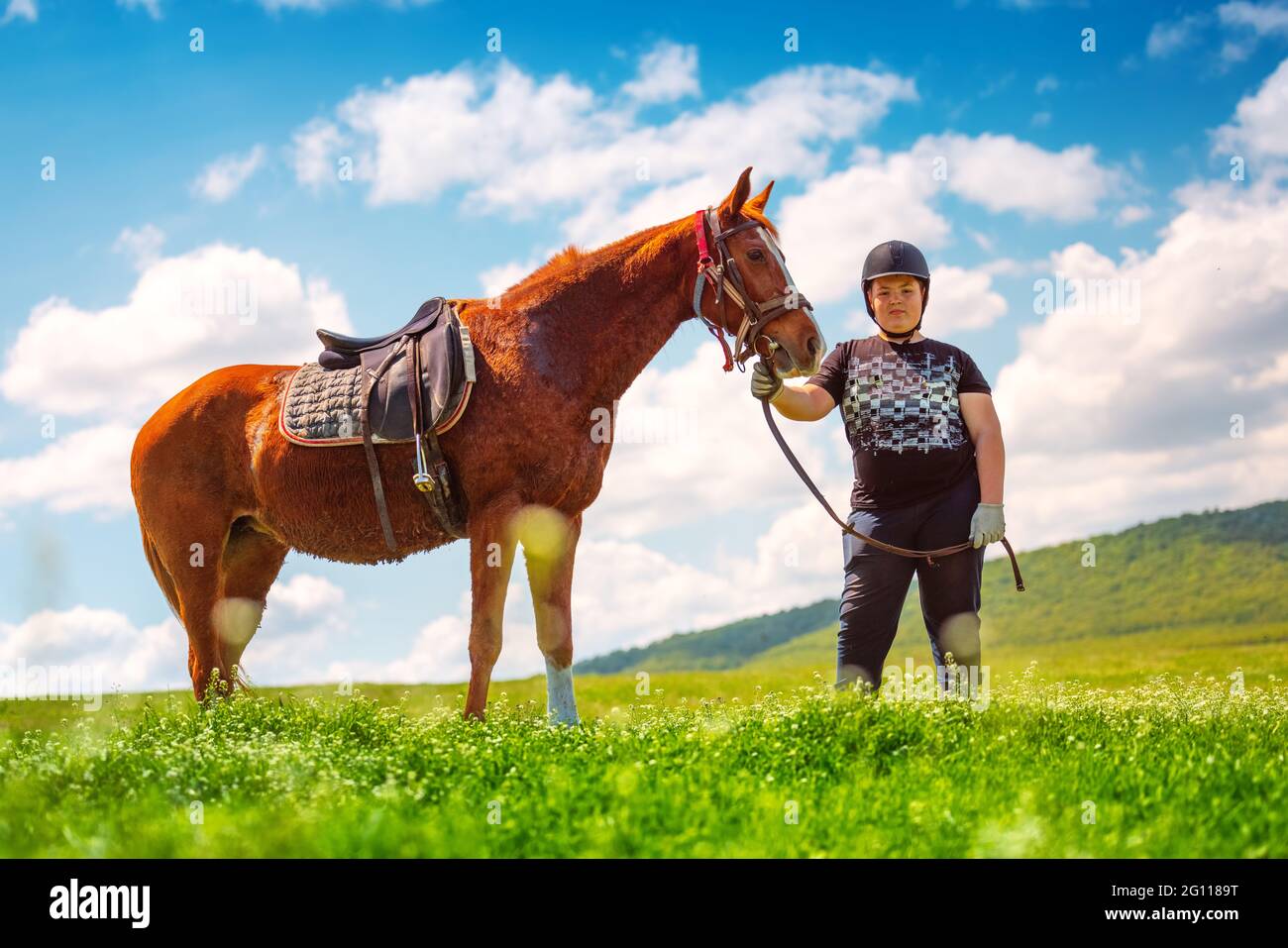 Young Boy riding a horse in the field Stock Photo