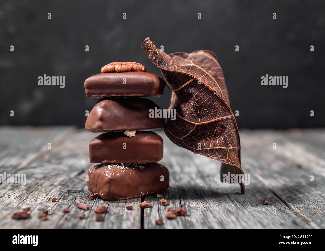 Dark handmade chocolate stack with dry leaf and cacao chips Stock Photo