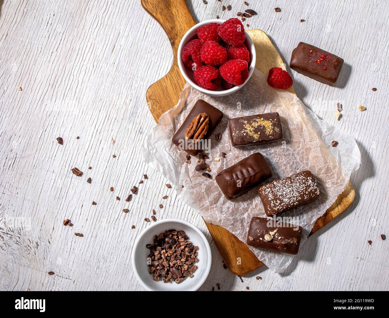 Dark handmade chocolate stack, coconut chips, rasberries and nuts Stock Photo