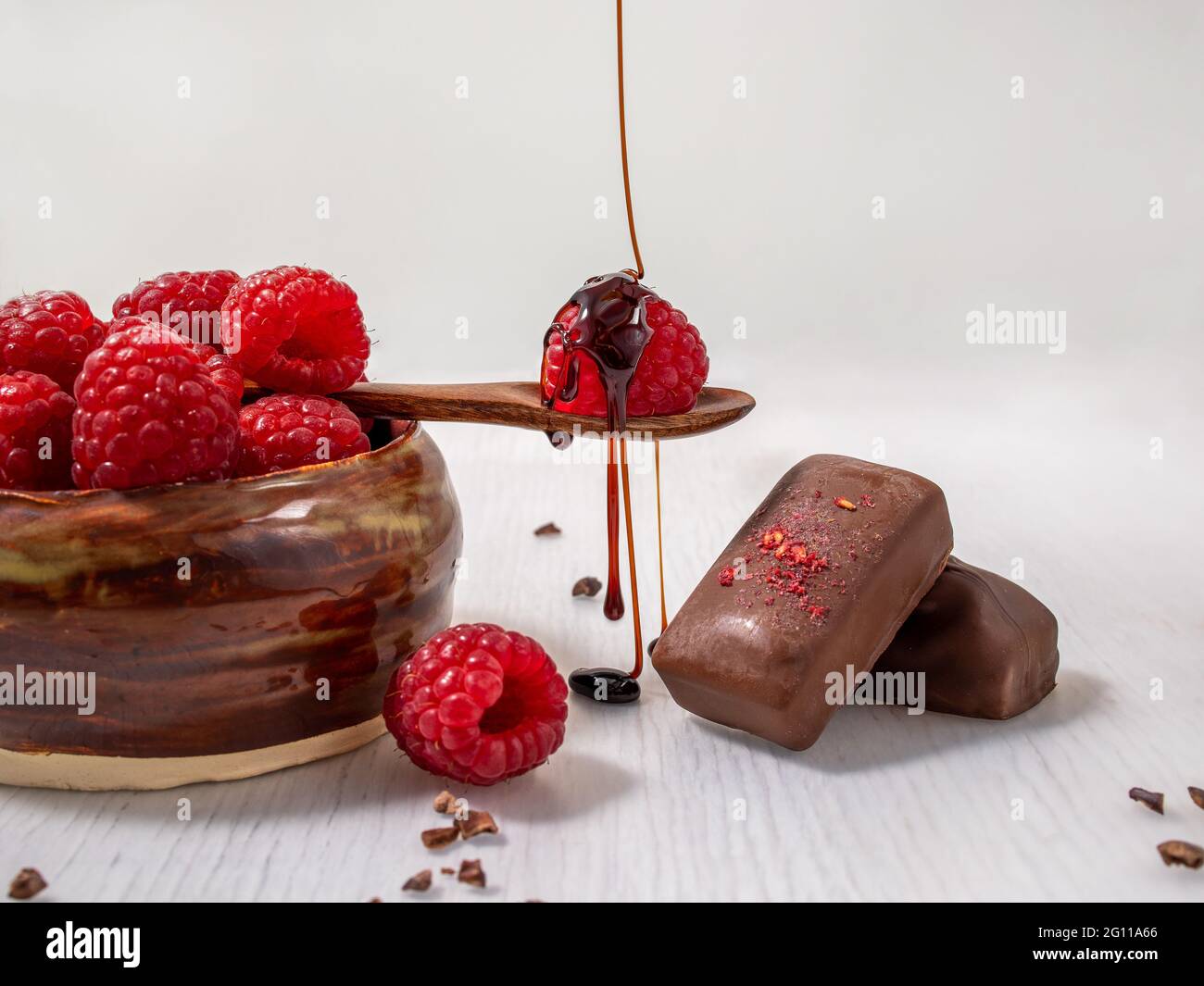 Dark handmade chocolate with raspberries and syrup Stock Photo