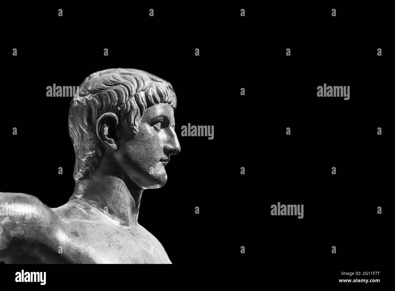 Black and white photo in close-up on face of ancient roman statue of young handsome man Stock Photo