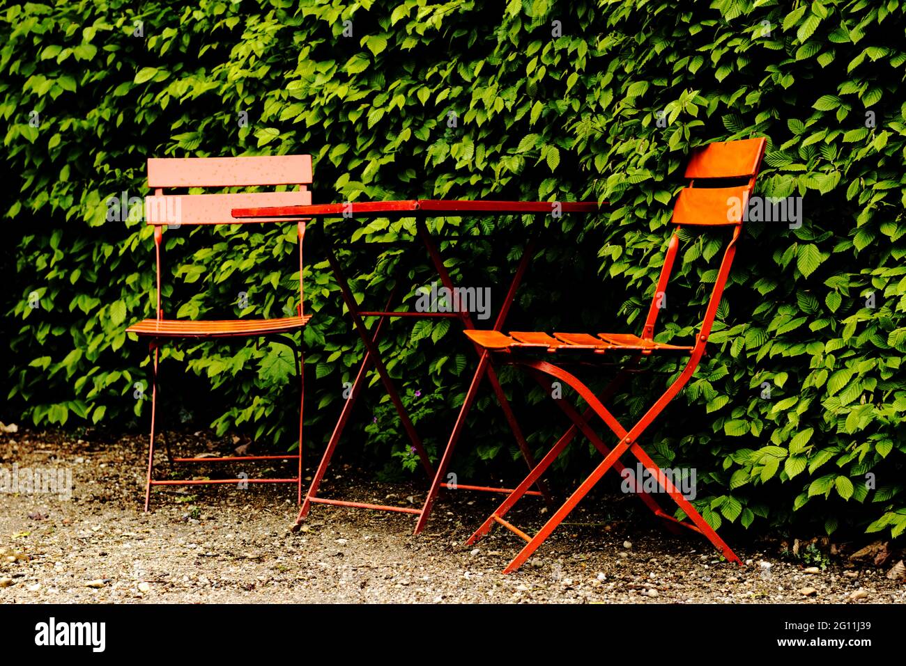 Red and metal garden table with chairs garden furniture Stock Photo